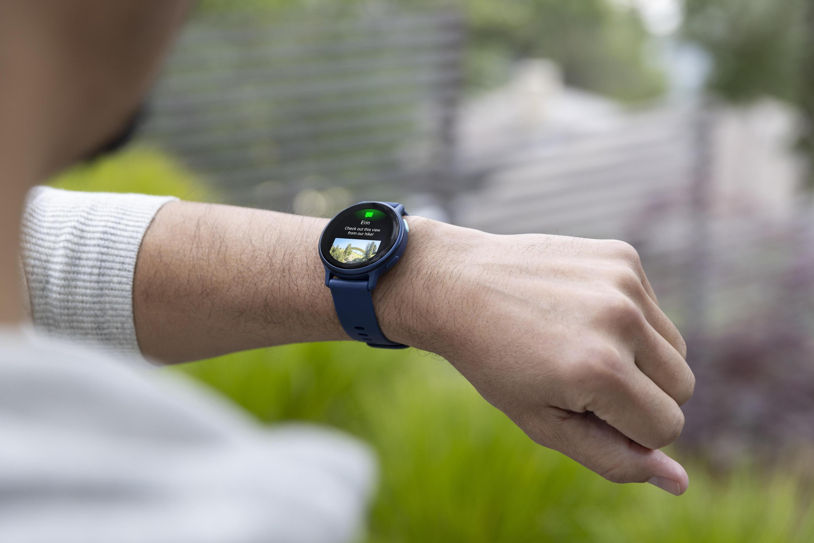 Osoba patrzy na smartwatch z wyświetlaczem. Zegarek jest na jej nadgarstku.