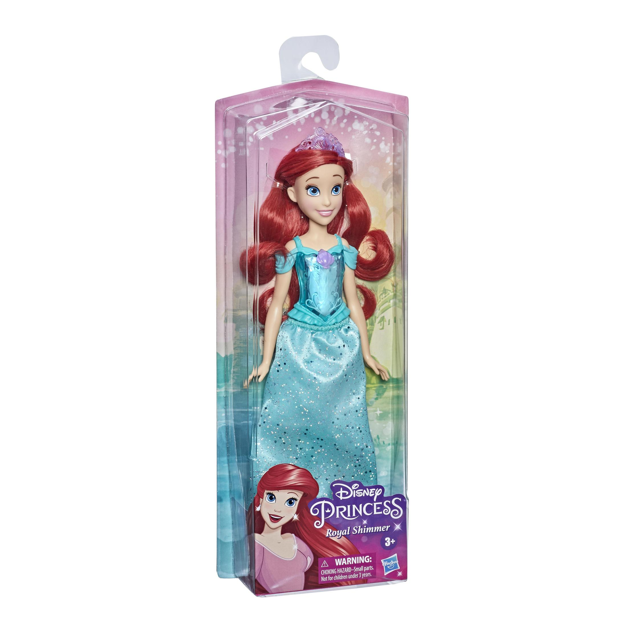 Bambola Ariel in una scatola di plastica. Ha i capelli rossi e un vestito blu. La scatola ha uno sfondo rosa.