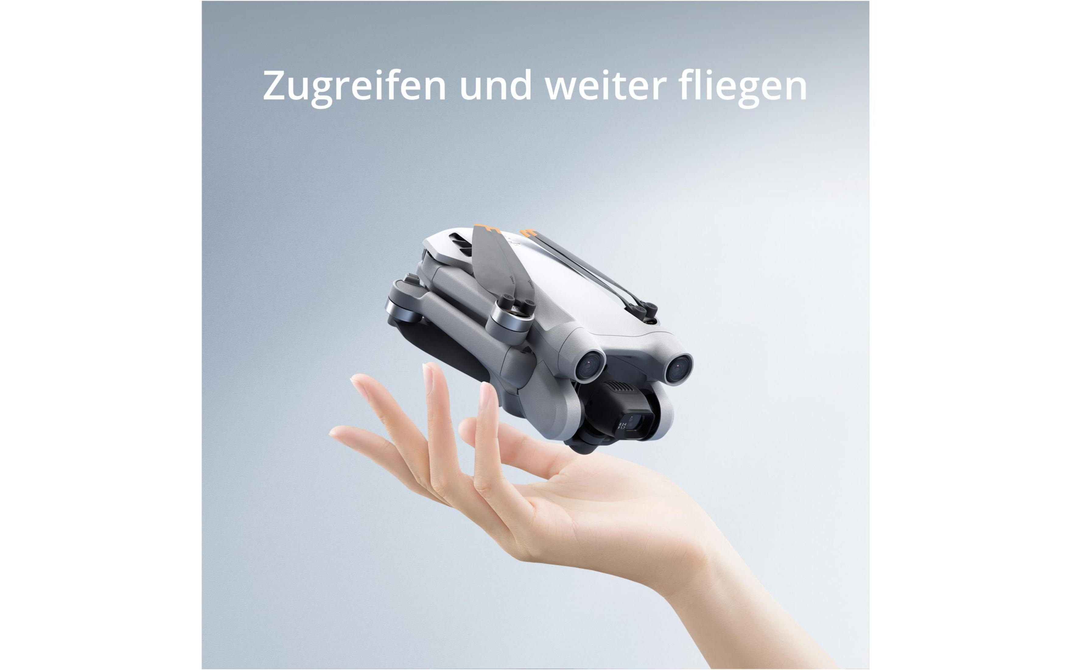 Eine Drohne in der Luft, gehalten von einer Hand. Graue Drohne, weißer Hintergrund. Text: Greifen und weiterfliegen.