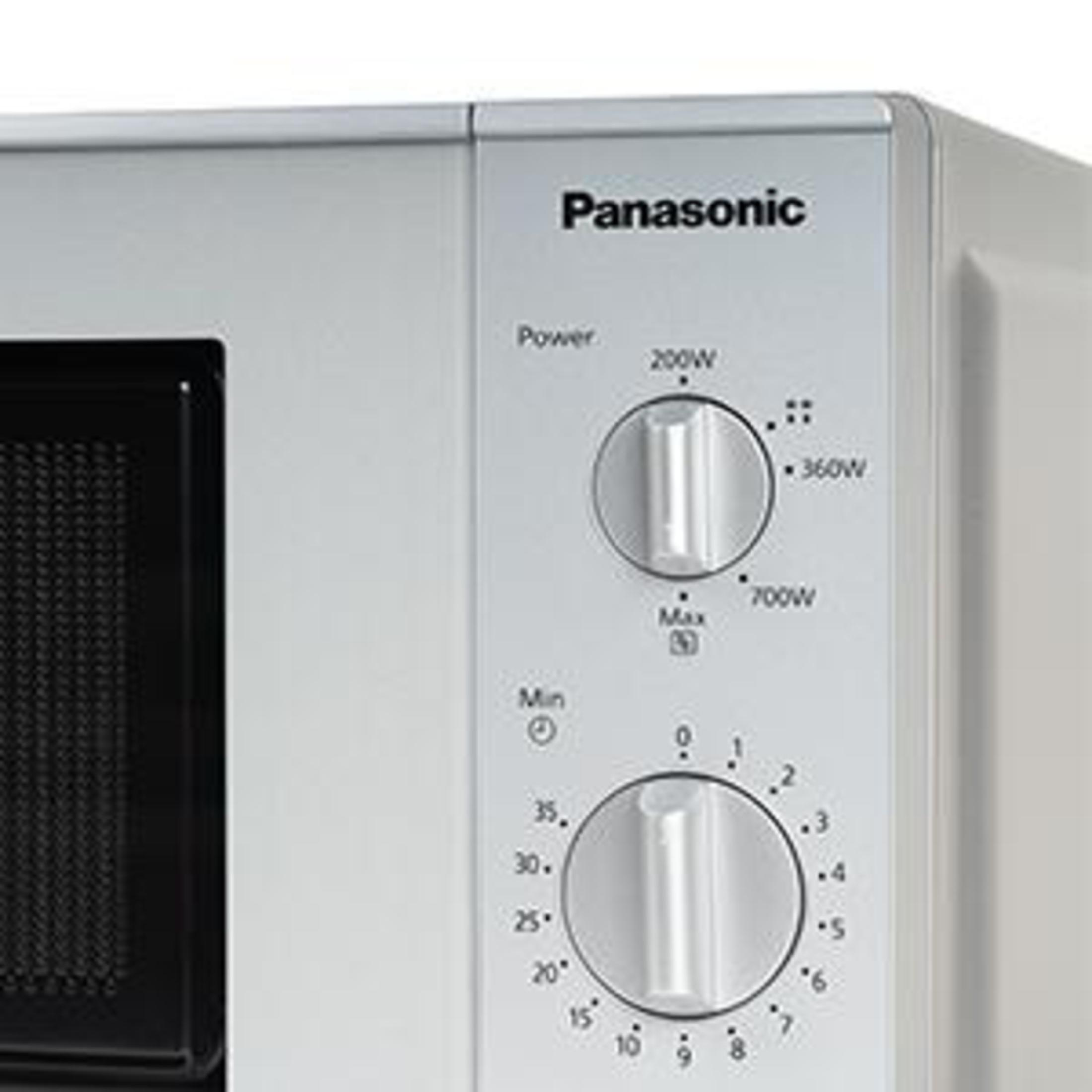 Zbliżenie panelu kuchenki mikrofalowej z pokrętłami i przyciskami. Białe tło.