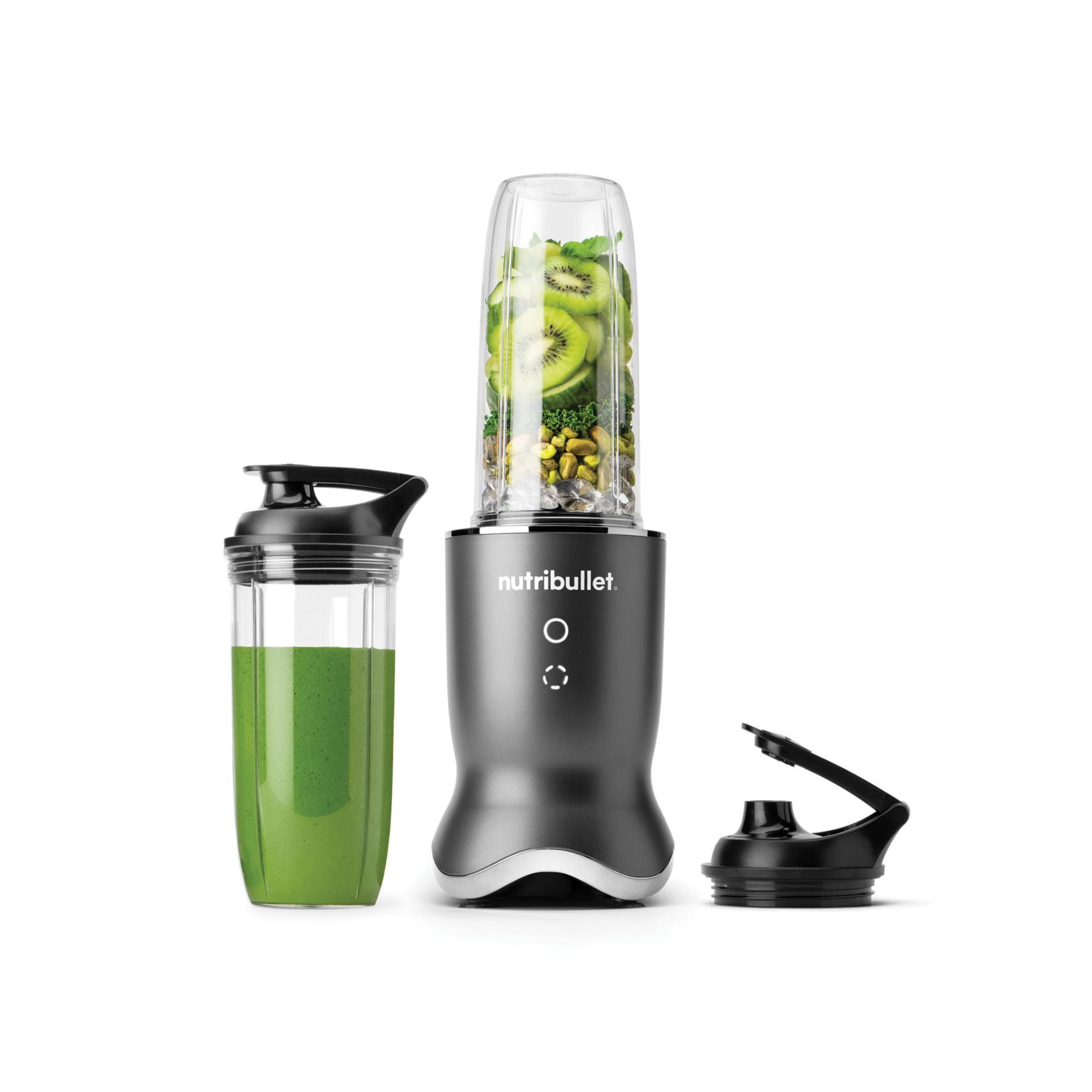Ein Mixer mit einem vollen Becher Zutaten und zwei zusätzlichen Bechern.