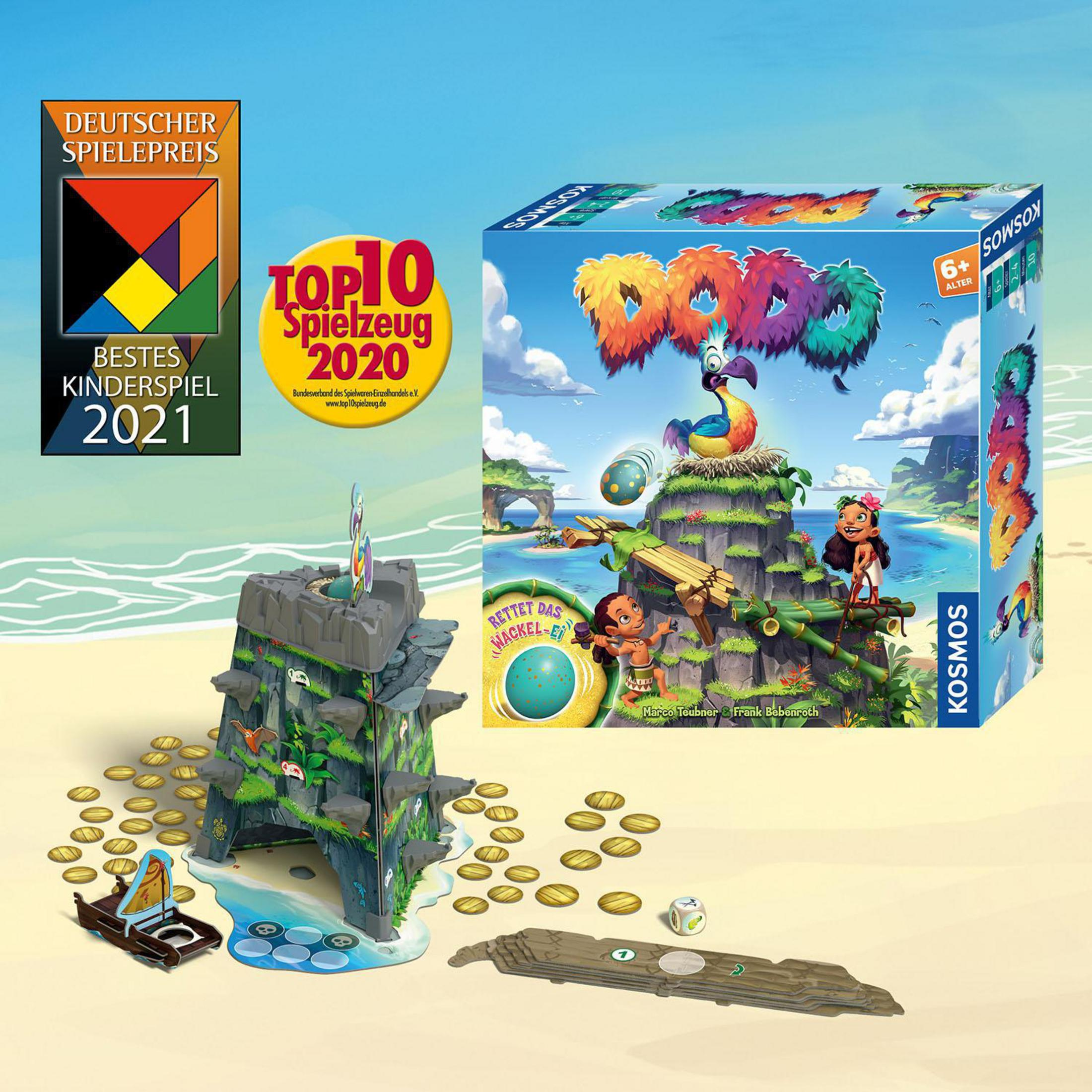 Ein Brettspielkasten mit einer bunten Insel, Spielsteinen und Auszeichnungen auf einem Sandstrand.