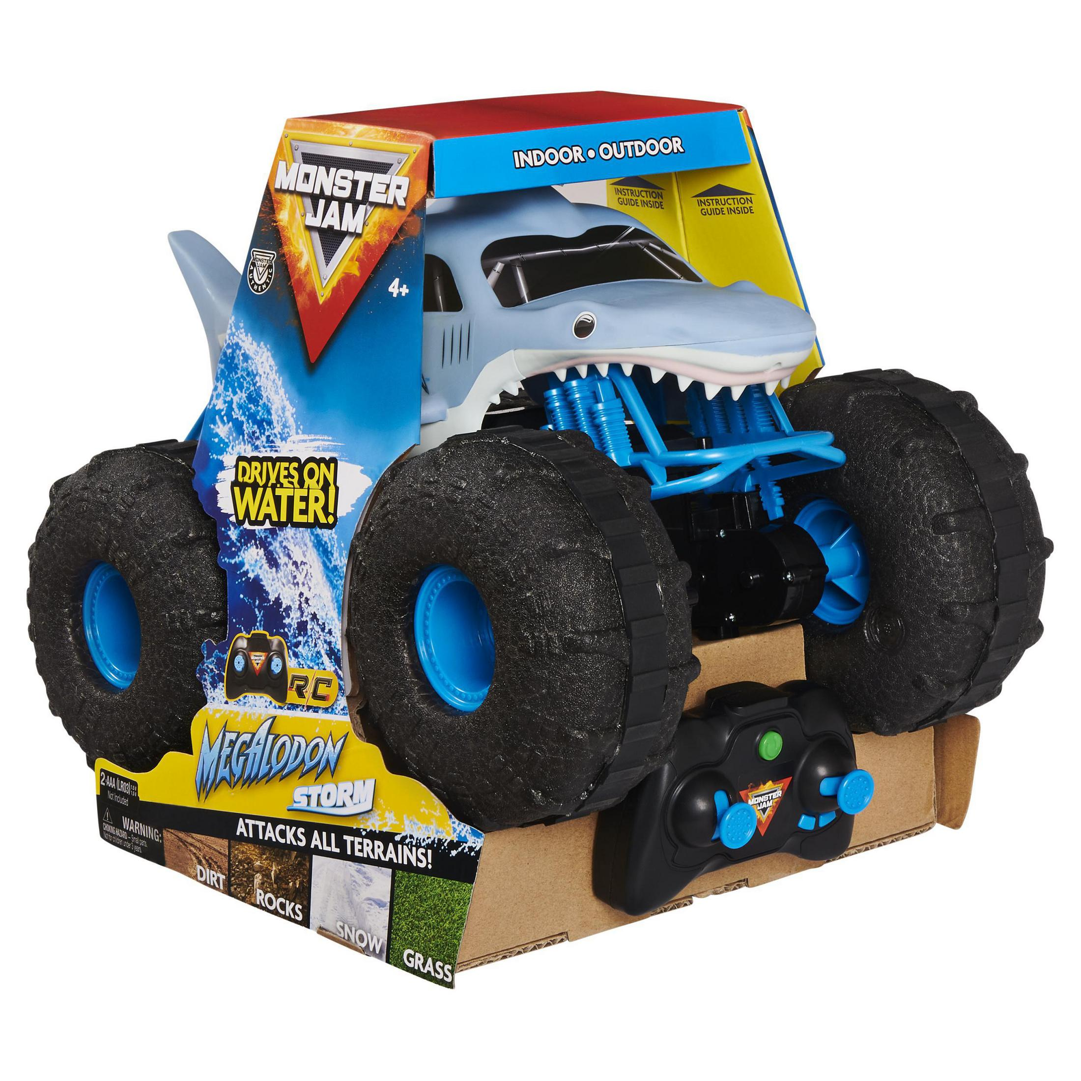 Zabawkowa ciężarówka z twarzą rekina na pudełku, z pilotem. Widnieje napis "Monster Jam" i "Drives on Water!"