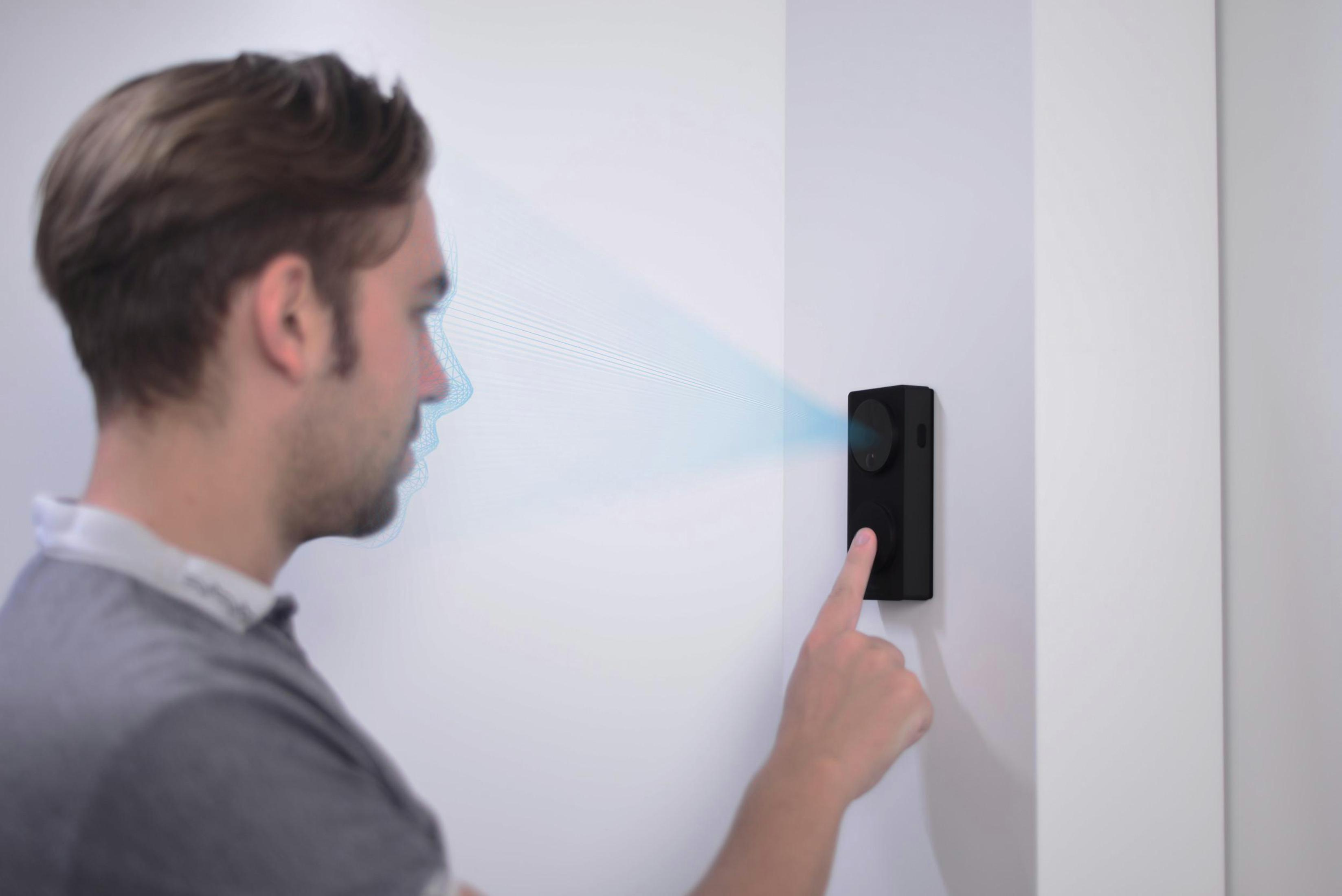 Ein Mann wird von einem Sicherheitssystem gescannt. Eine schwarze Tafel ist an der Wand. Blaue Linien zeigen den Scan.