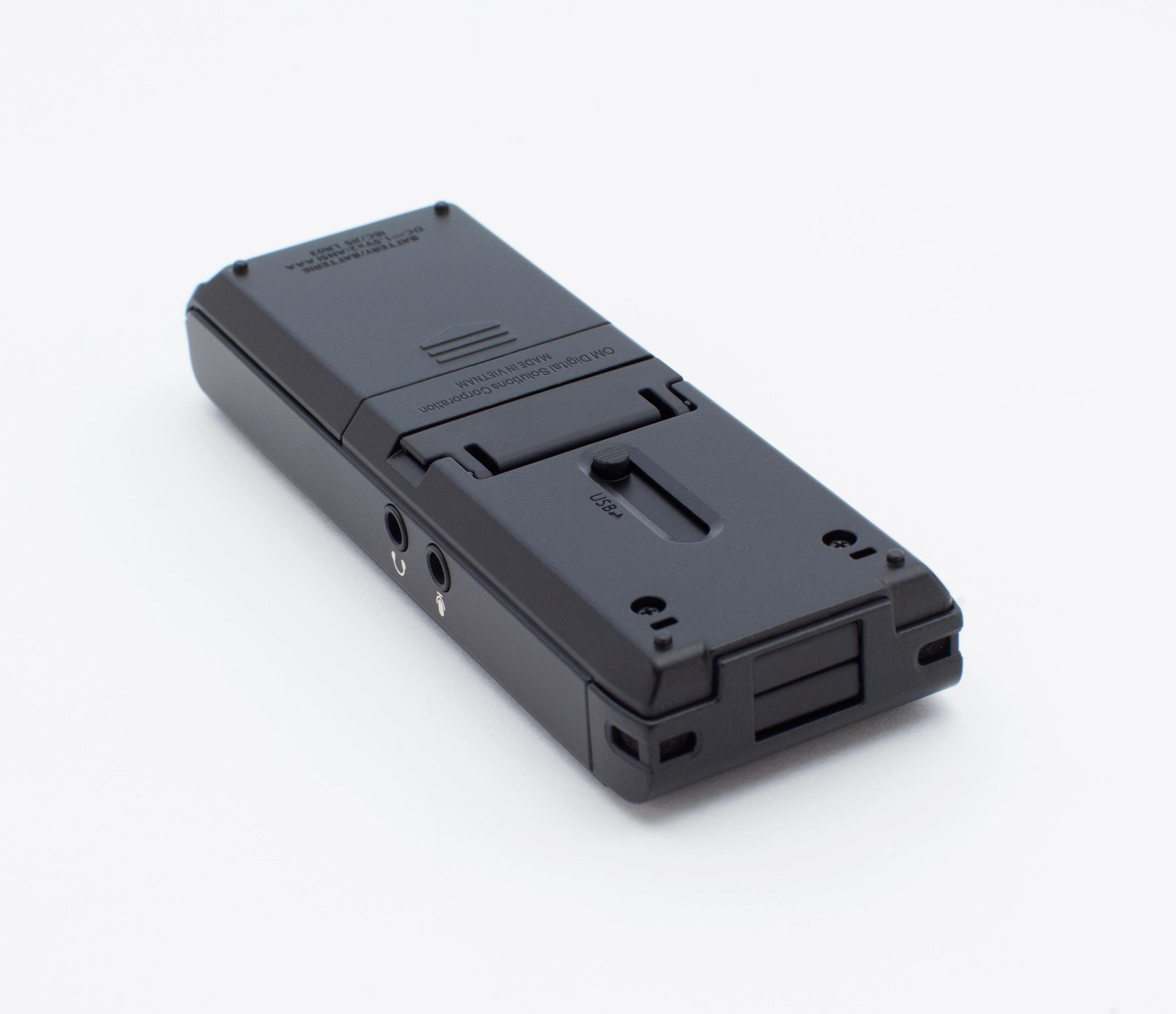 Czarne urządzenie, prawdopodobnie cyfrowy rejestrator głosu, na białej powierzchni.