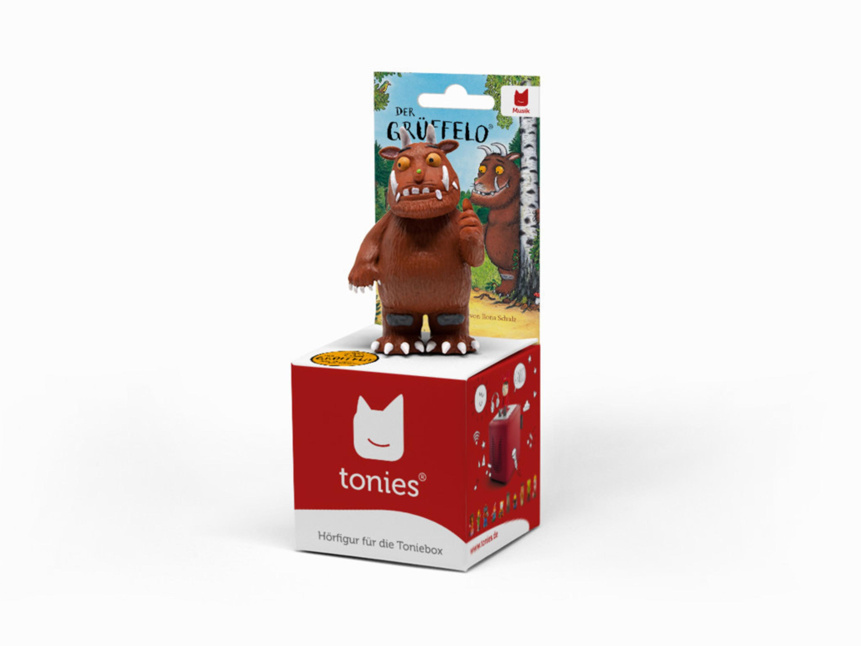 Gruffalo-Spielzeug auf einer Schachtel. Buchcover sichtbar. Rote und weiße Verpackung.