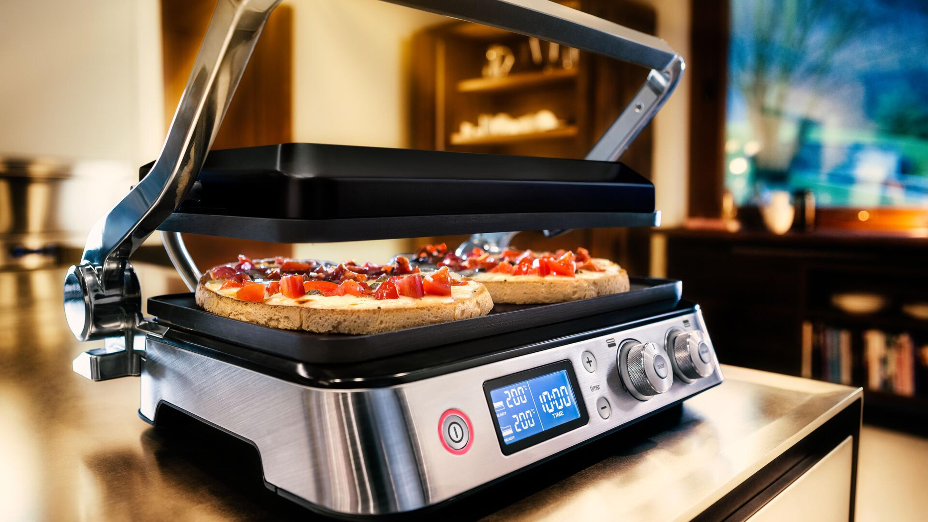 Grill z dwoma tostami z pomidorami i wyświetlaczem cyfrowym.