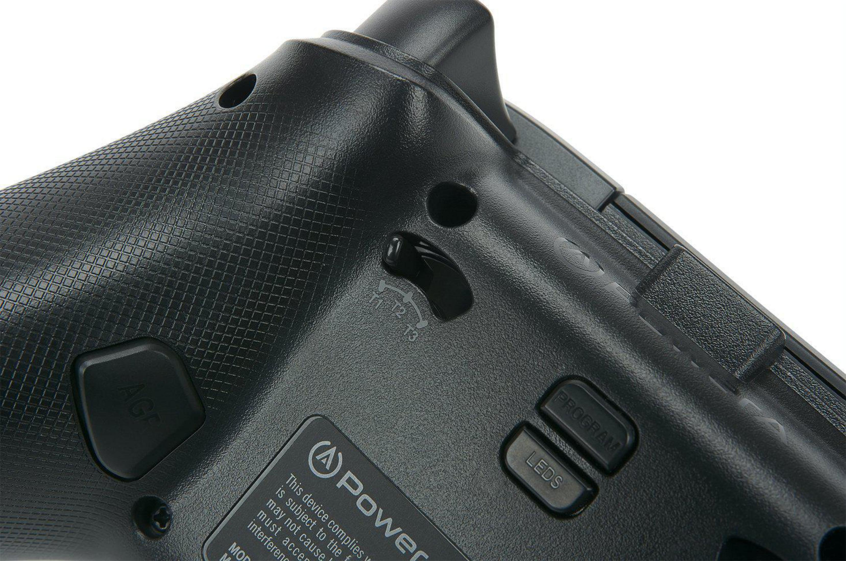 Rückseite des schwarzen Gamecontrollers. Knöpfe und ein Schalter sind sichtbar. Nahaufnahme.