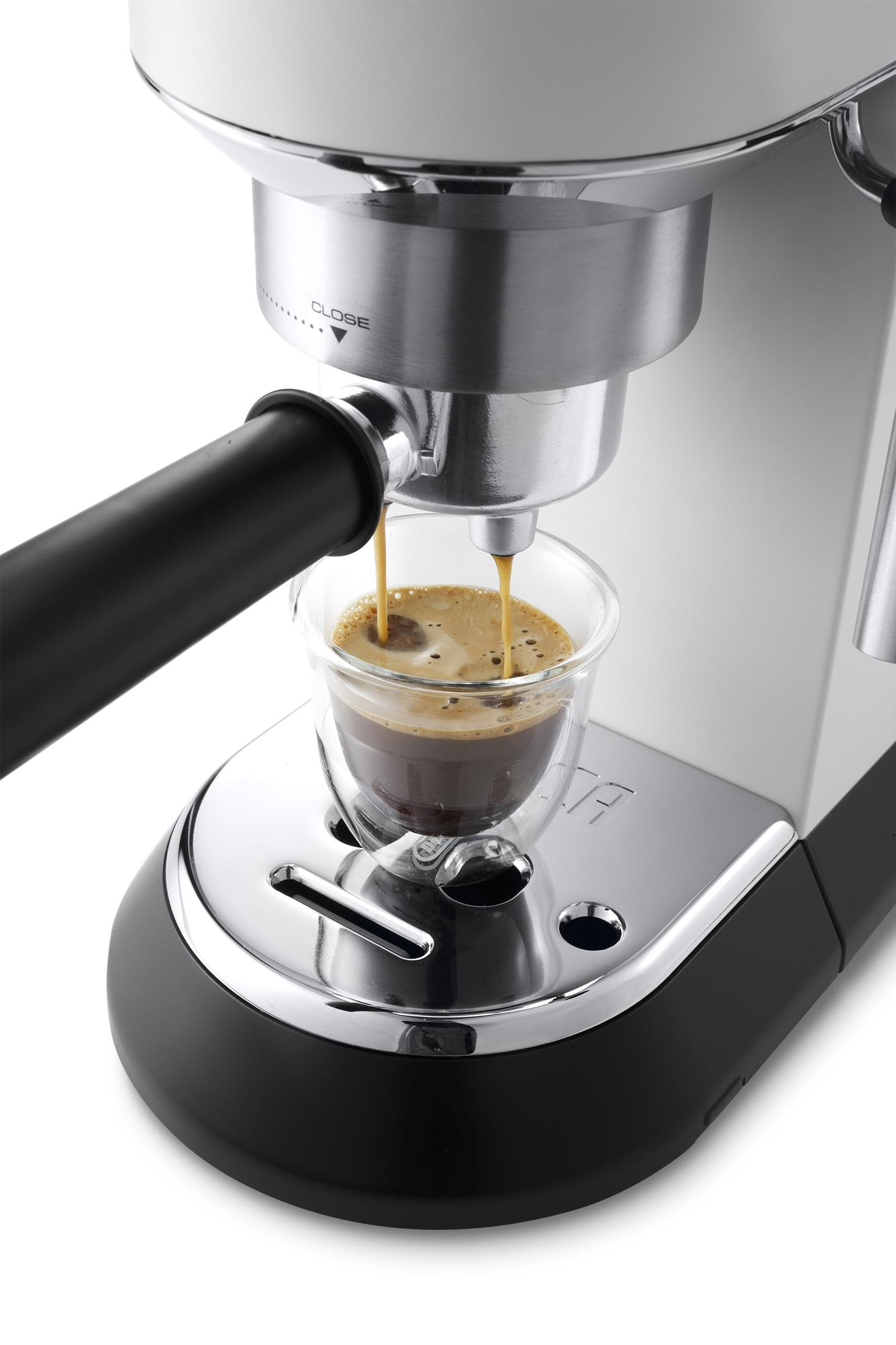 Ekspres do espresso wlewający kawę do szklanki. Maszyna jest srebrna i czarna.