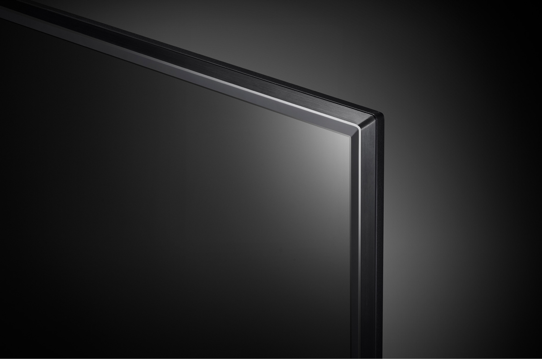 Primo piano sulla cornice nera di un televisore, che mostra un angolo su sfondo scuro.