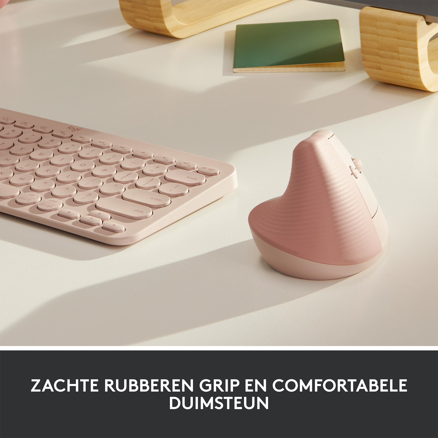 Różowa mysz i klawiatura ergonomiczna na białym biurku. Tekst: ZACHTE RUBBEREN GRIP EN COMFORTABELE DUIMSTEUN.
