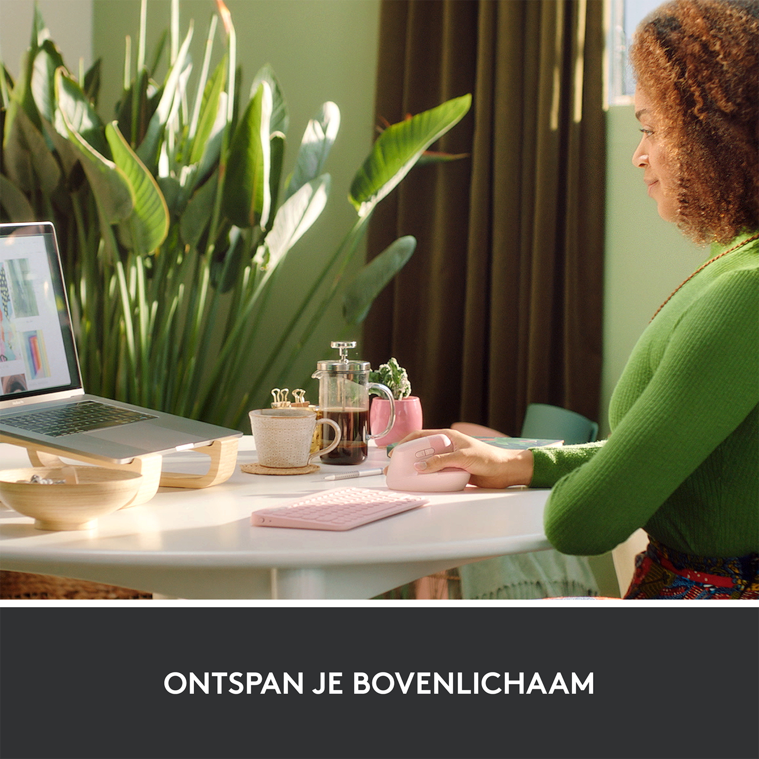 Kobieta pracuje na laptopie, z różową myszą i klawiaturą na białym stole.