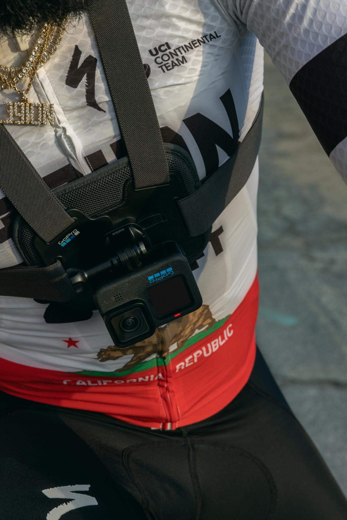 Radfahrer mit GoPro-Brusthalterung, rot-weißes Trikot.