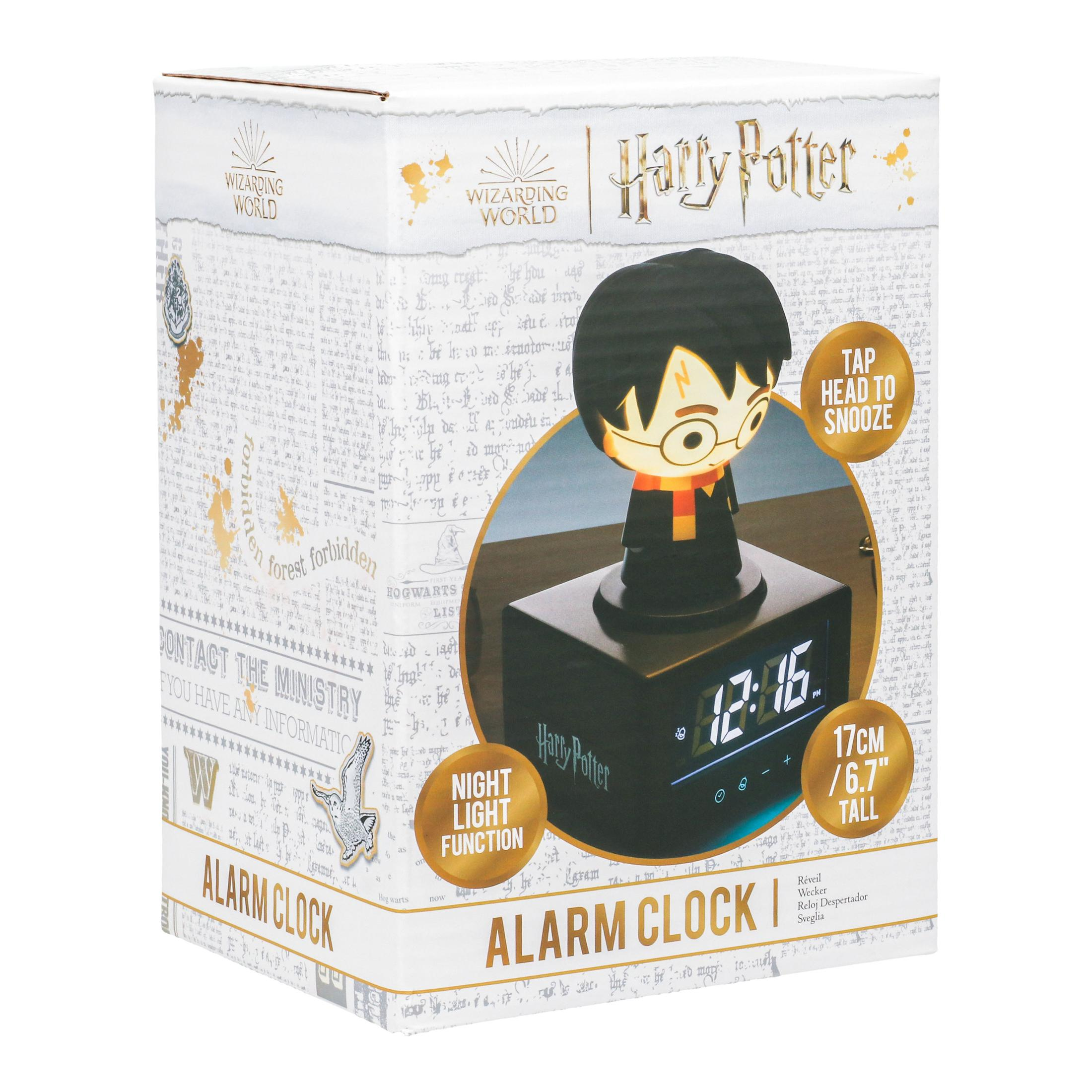 Budzik Harry'ego Pottera w pudełku. Zegar pokazuje godzinę. Na górze figurka Harry'ego Pottera.