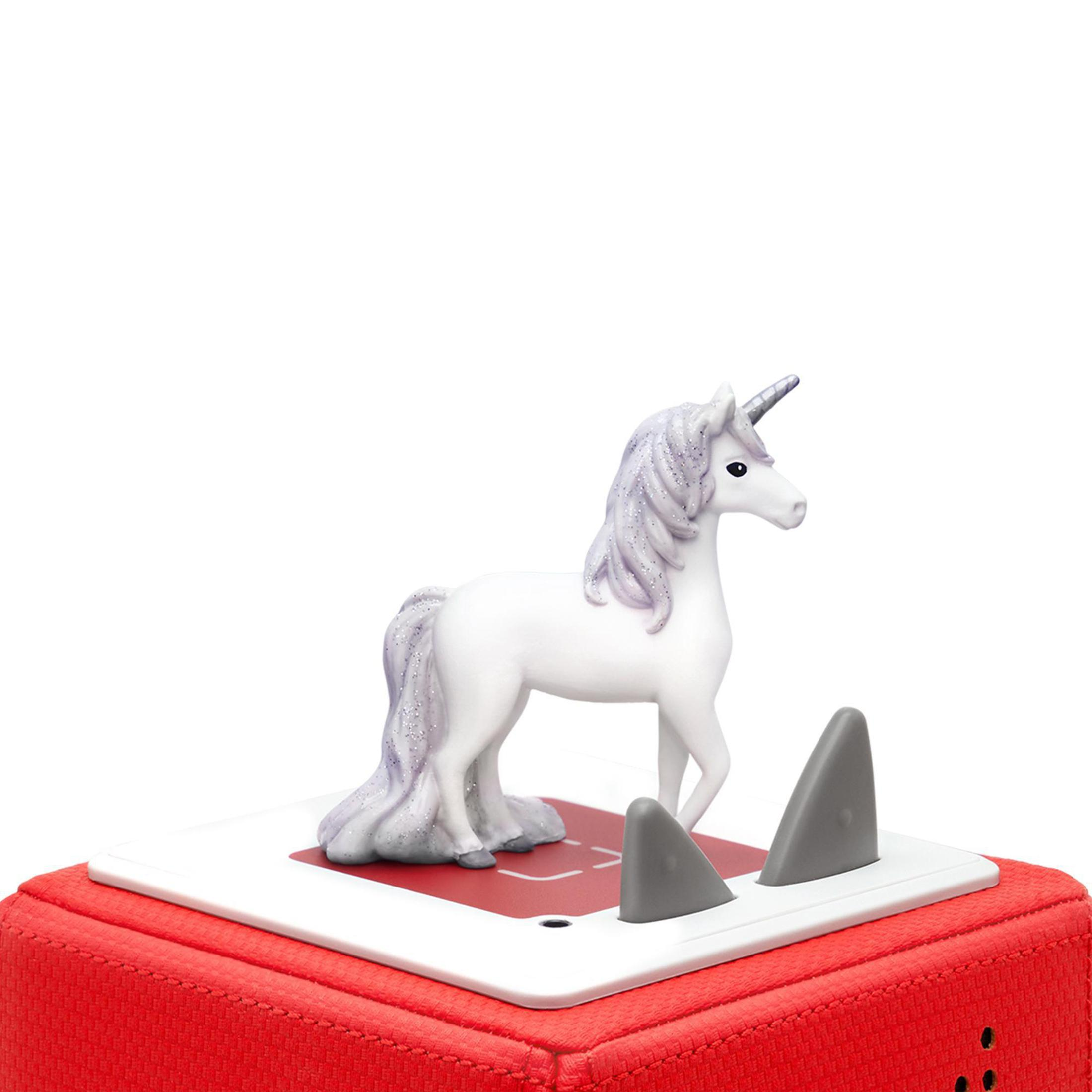 Figurine de licorne blanche sur une base rouge et blanche. Fond blanc.