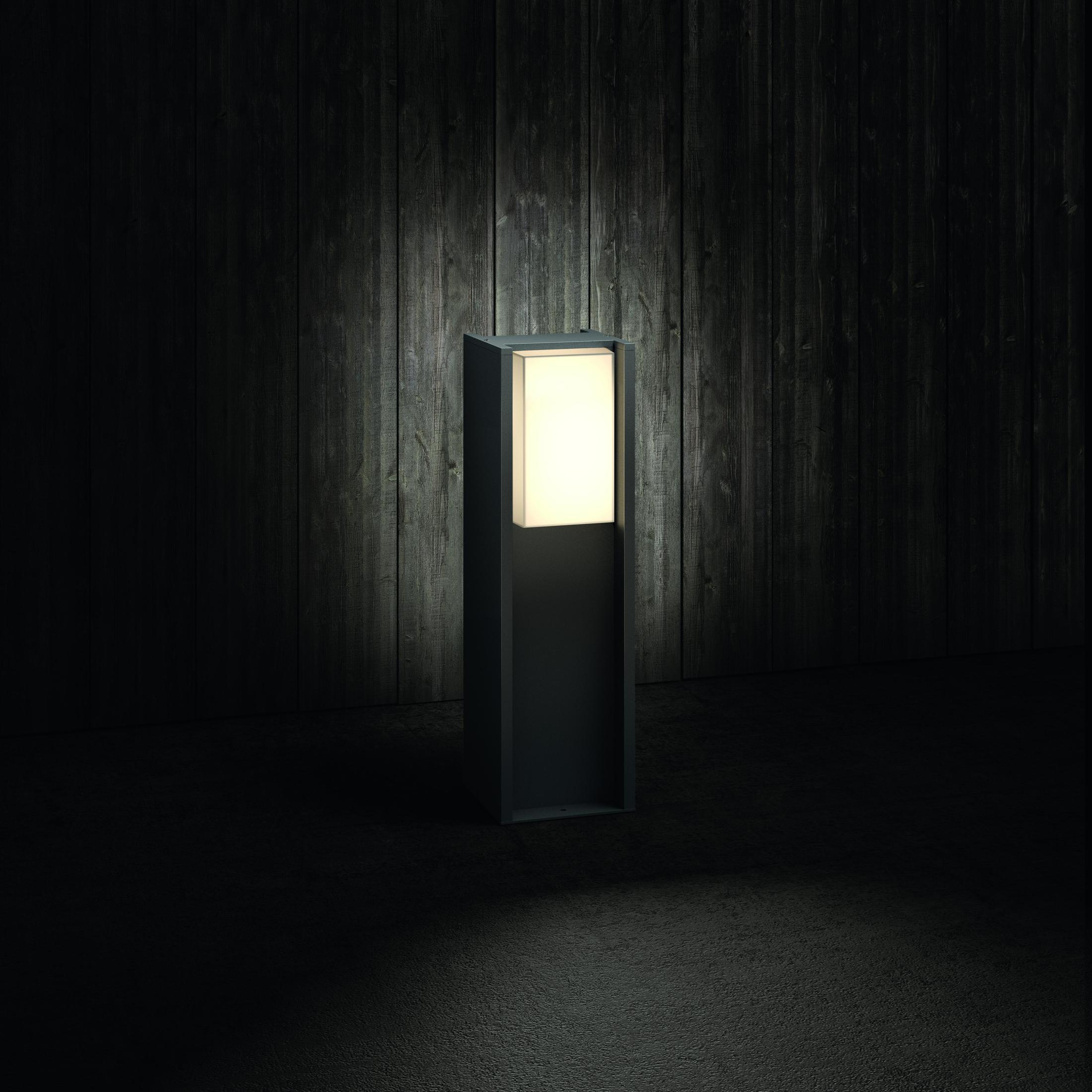 Czarna oprawa oświetleniowa zewnętrzna podświetlona na ciemnym tle.