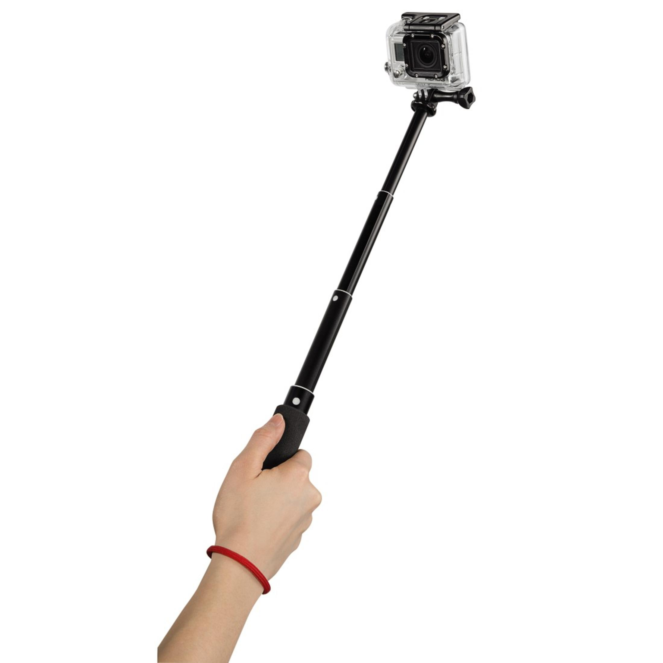 Eine Hand hält einen schwarzen Selfie-Stick mit Kamera. Rotes Armband.