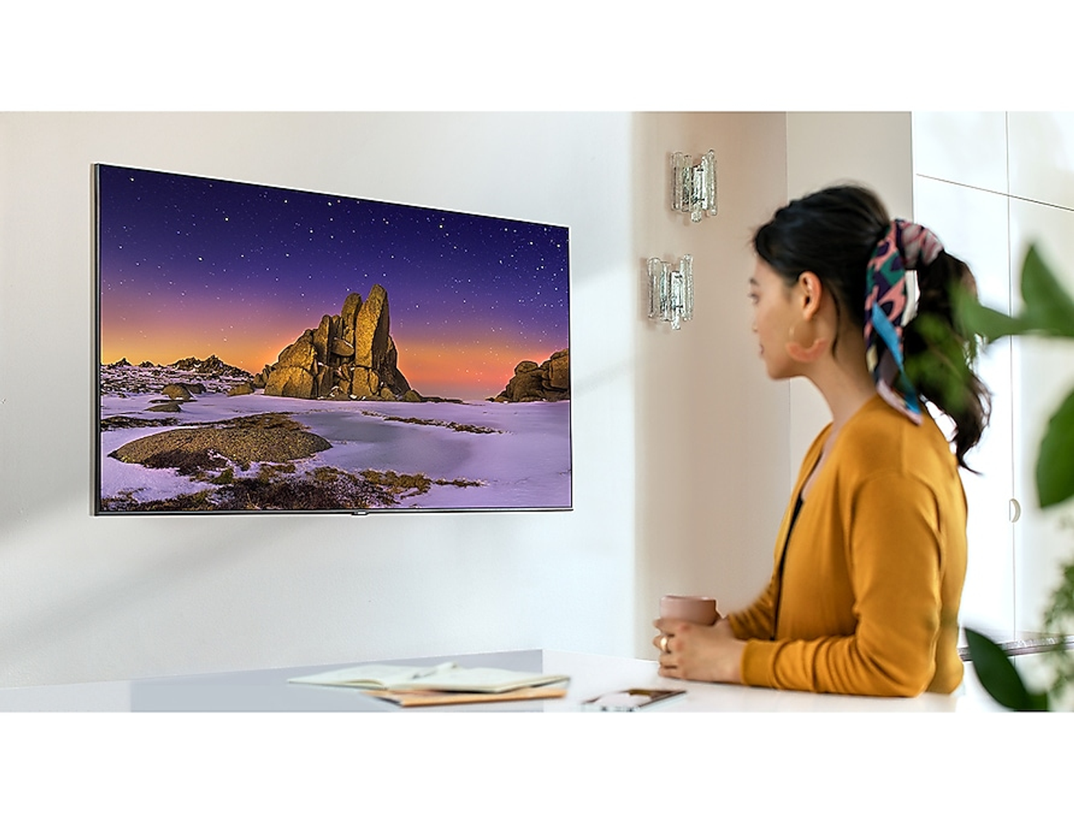 Un televisor que muestra un patrón abstracto colorido, con un soporte curvo.