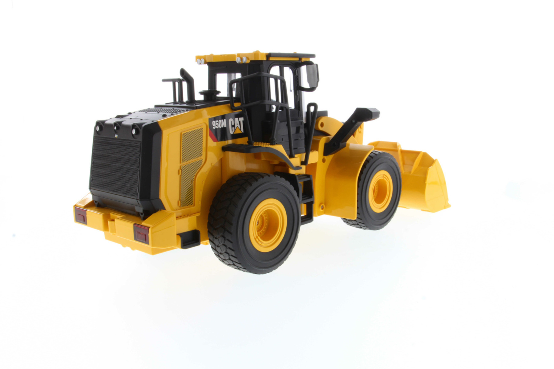 Gelber Caterpillar 950M-Frontlader auf weißem Hintergrund. Schwarze Akzente und Reifen.