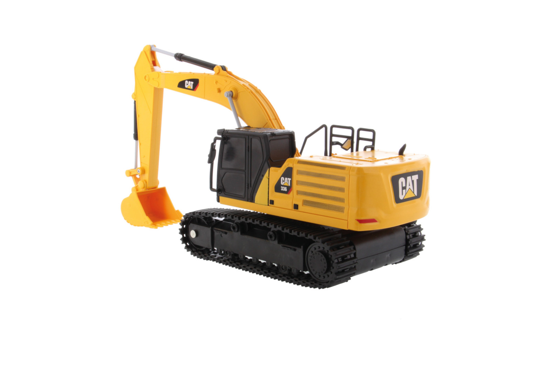 Excavadora CAT amarilla y negra de juguete aislada sobre fondo blanco.