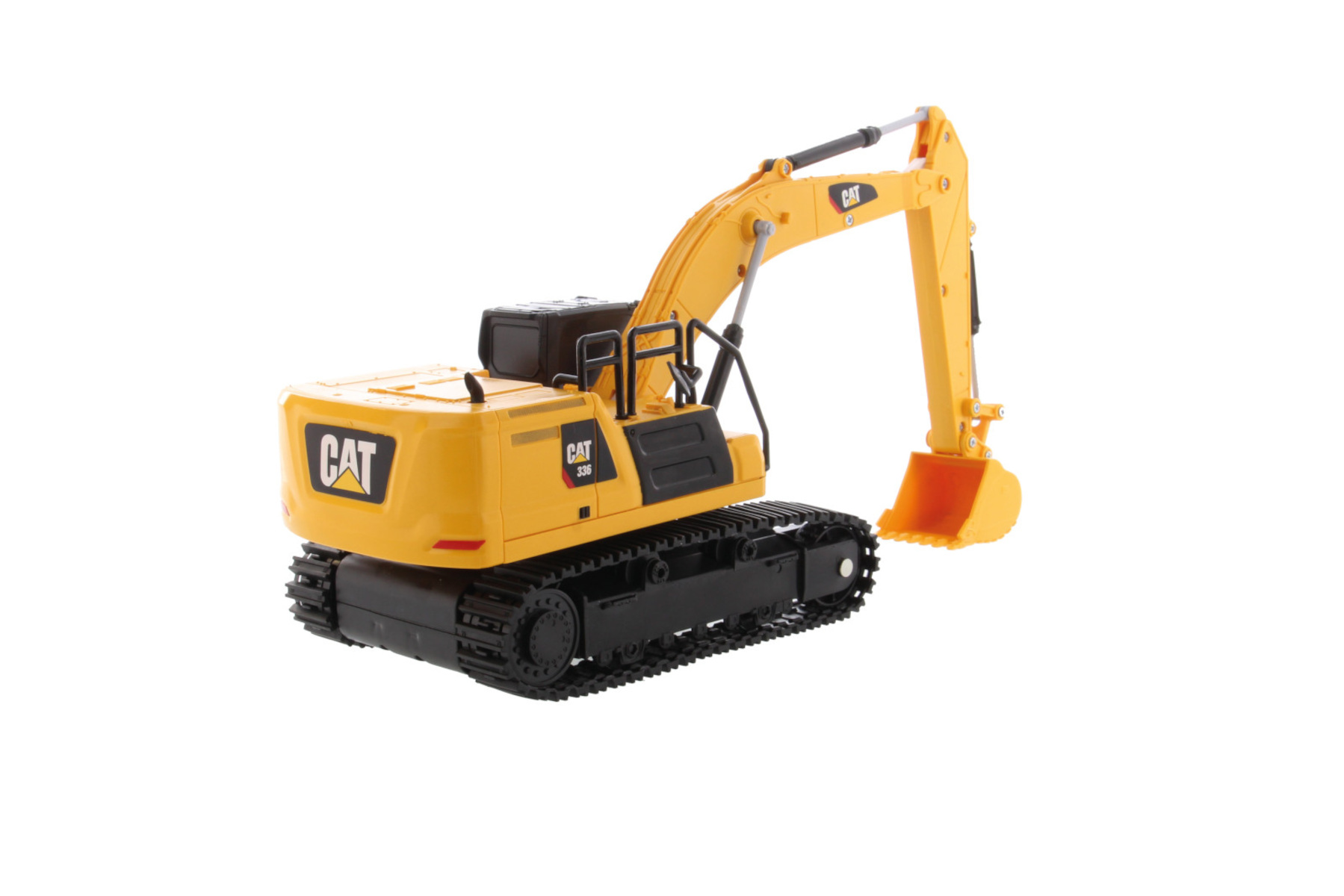 Excavadora de juguete CAT 330 amarilla con orugas negras y brazo levantado en blanco.