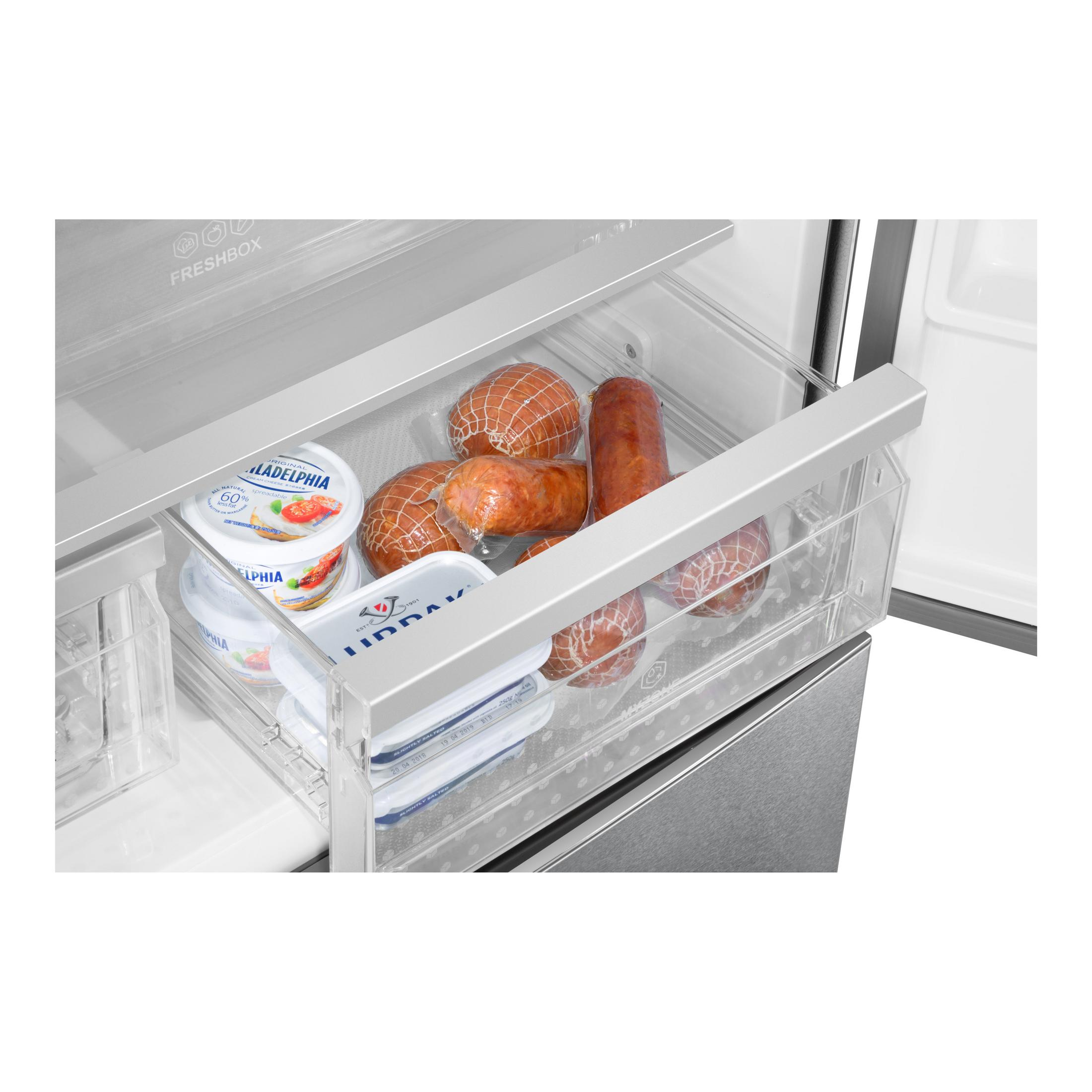 Un cassetto del frigorifero pieno di alimenti confezionati, tra cui formaggio e salsicce.