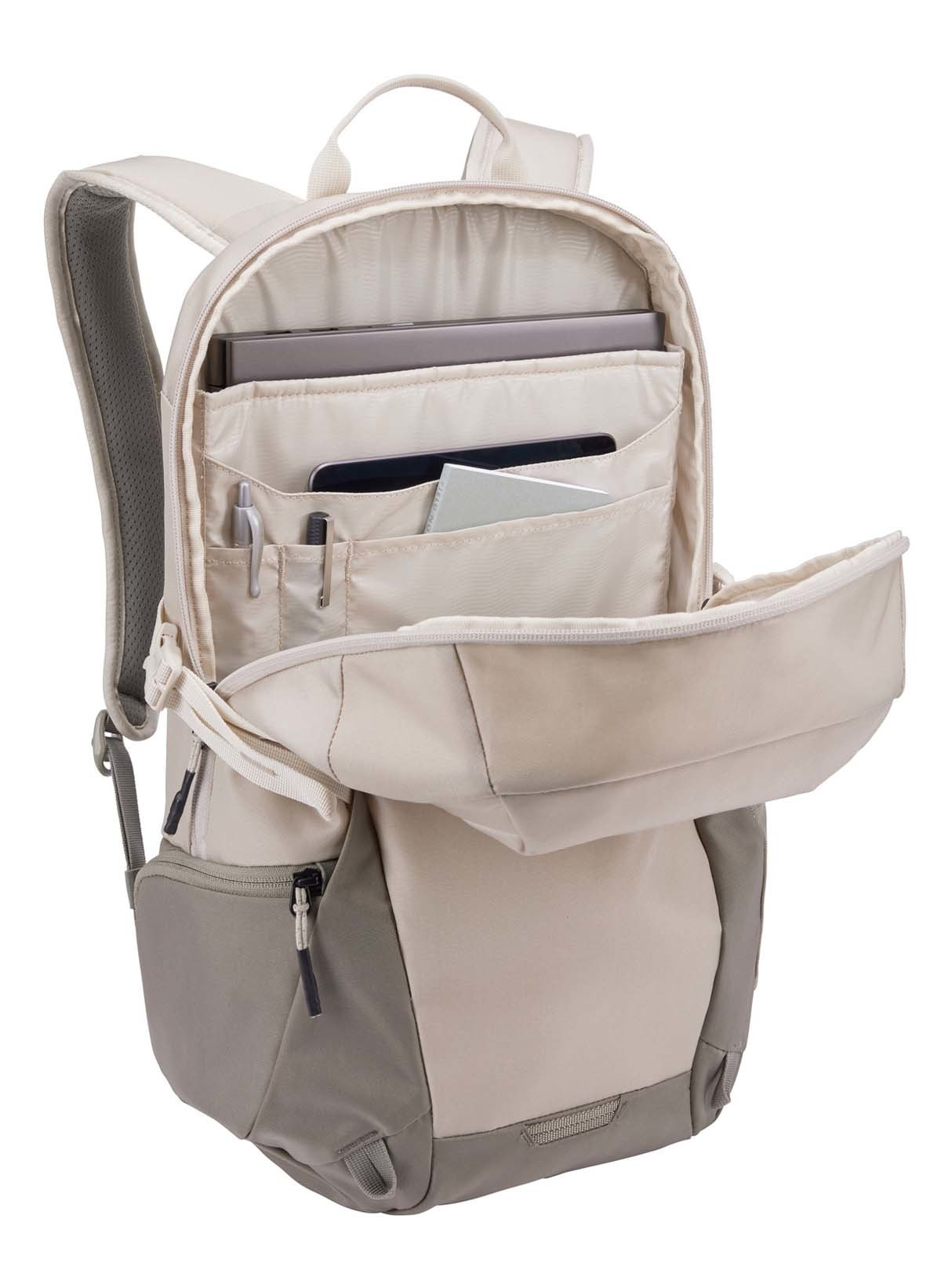Offener beiger Rucksack mit mehreren Taschen, der Stifte, ein Tablet und andere Gegenstände zeigt, weißer Hintergrund.