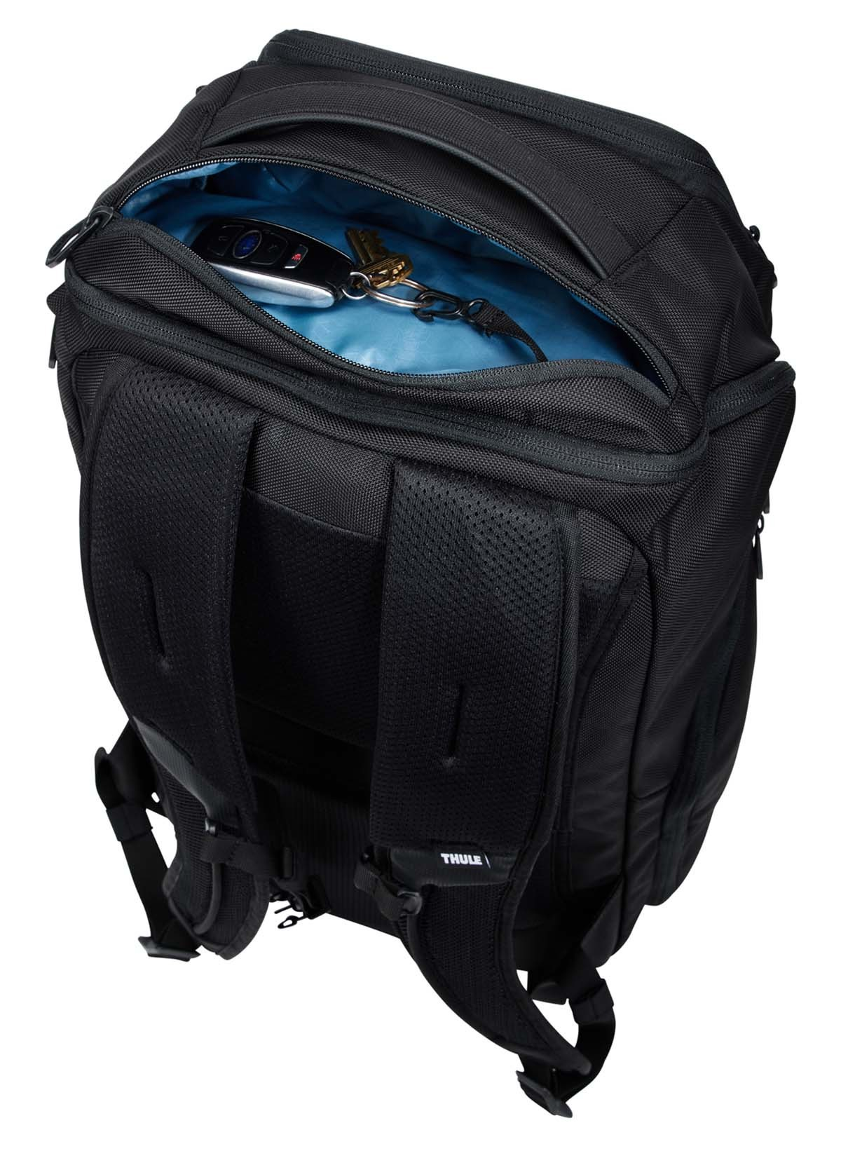 Ein schwarzer Rucksack mit offenem Deckel, der Gegenstände im Inneren zeigt, auf weißem Hintergrund, modernes Design.
