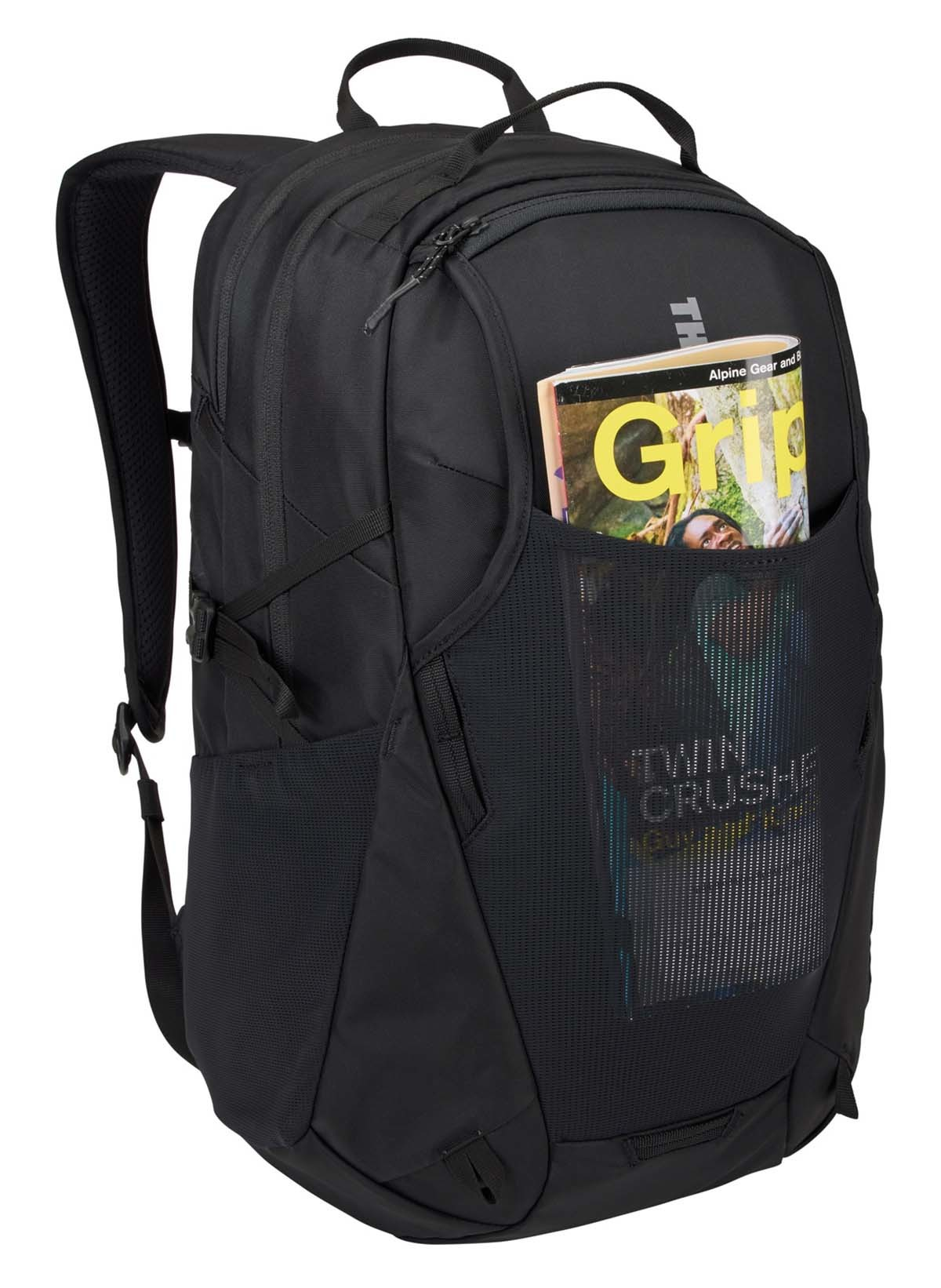 Mochila negra con una revista en el bolsillo de malla frontal; logo de Thule visible.