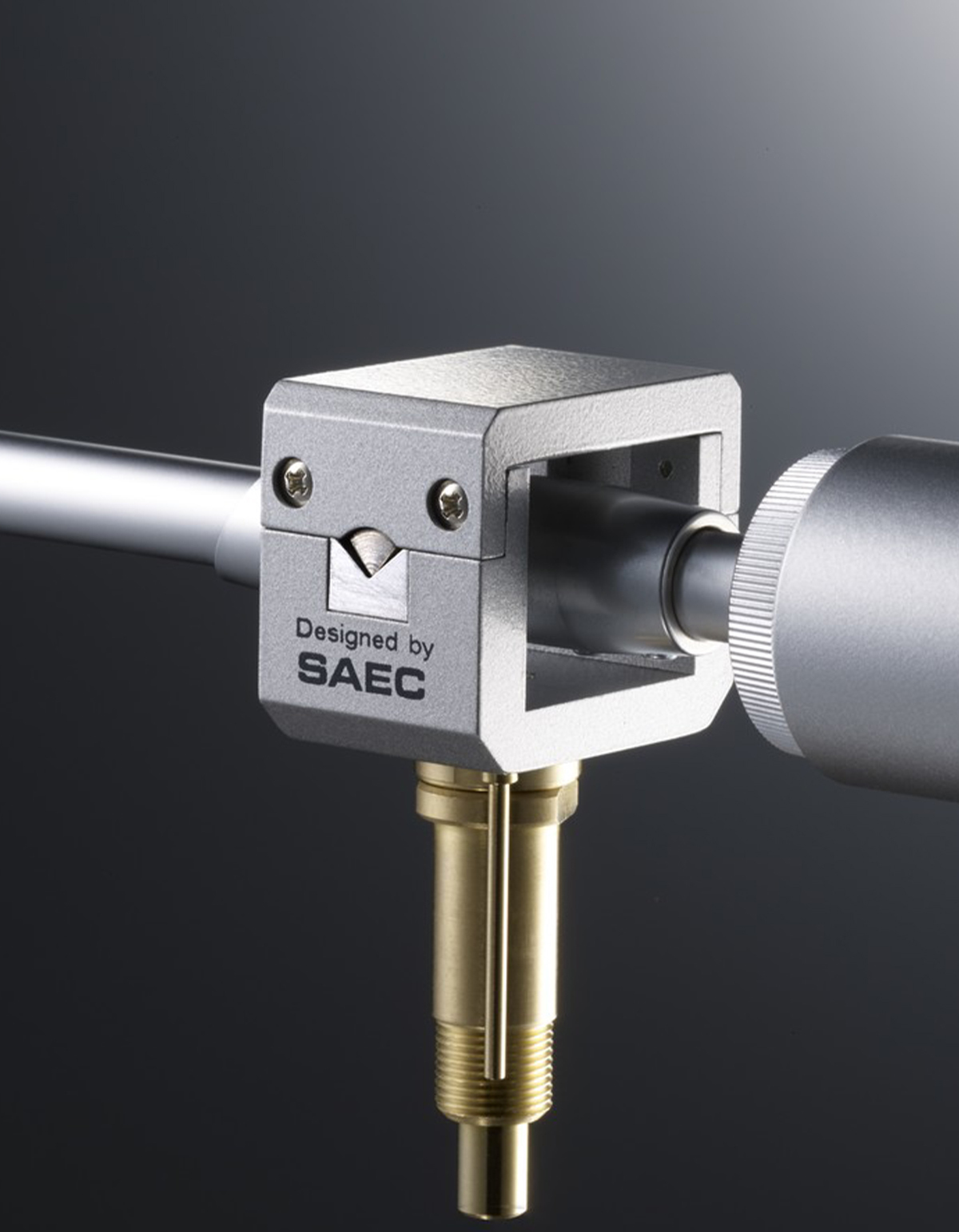 Primer plano de un dispositivo SAEC plateado, con un tubo metálico y un conector dorado.