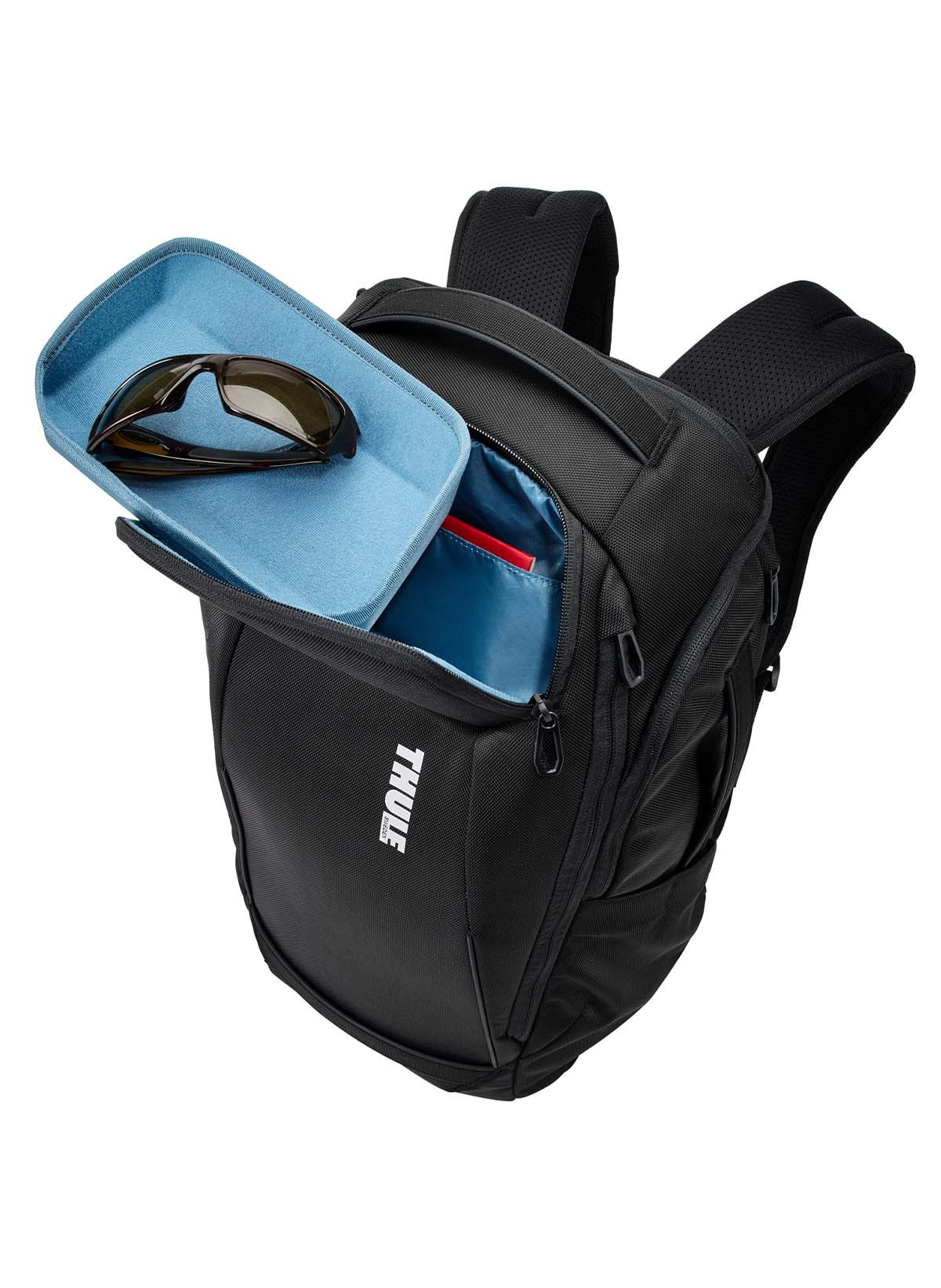 Schwarzer Rucksack mit blauem Tablett und Sonnenbrille. Offene Tasche sichtbar.