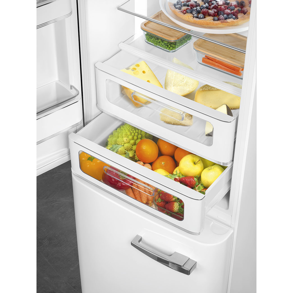 Refrigerador abierto con cajones llenos de frutas, queso y verduras. Interior blanco.
