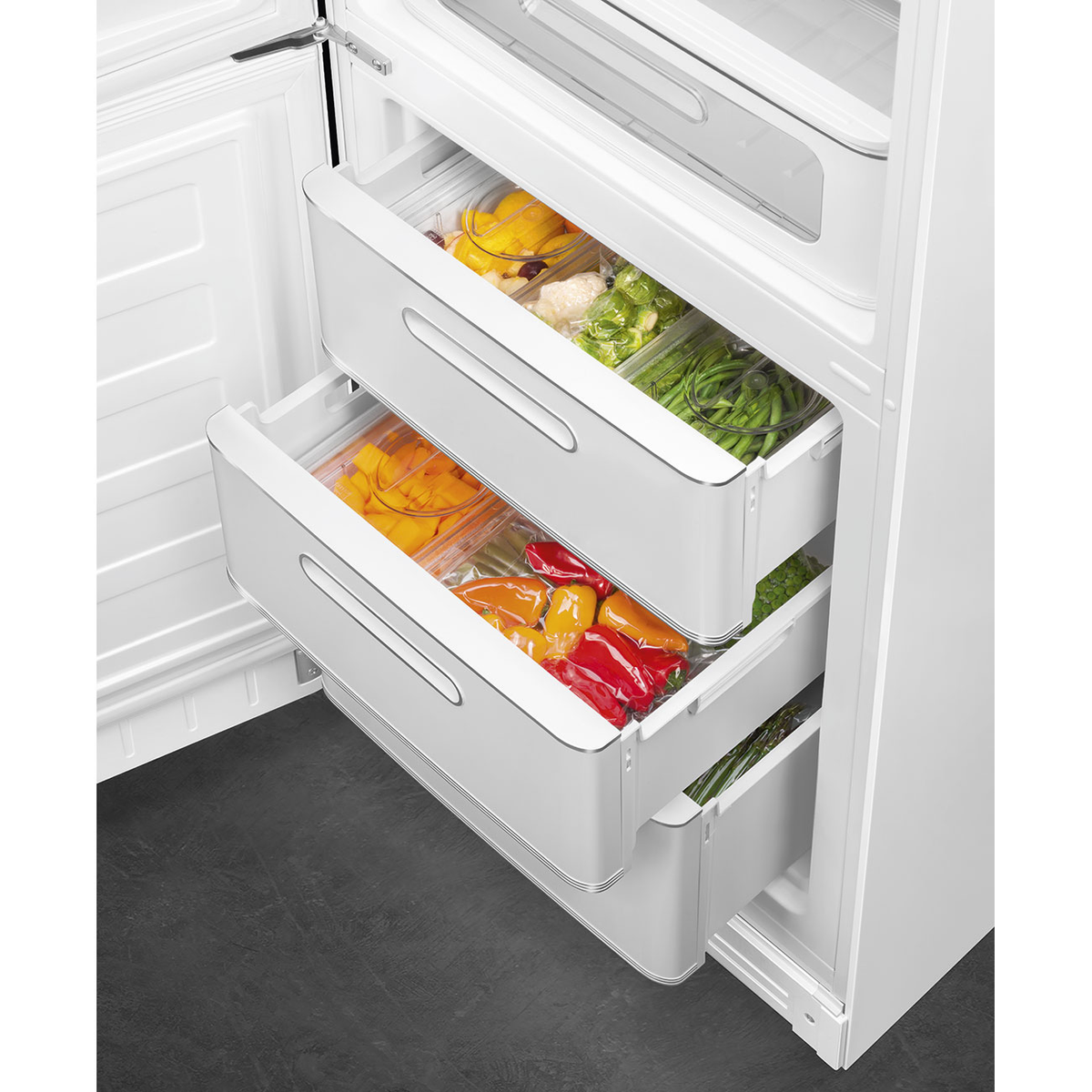 Cajones de refrigerador con productos organizados: pimientos, judías y coliflor.