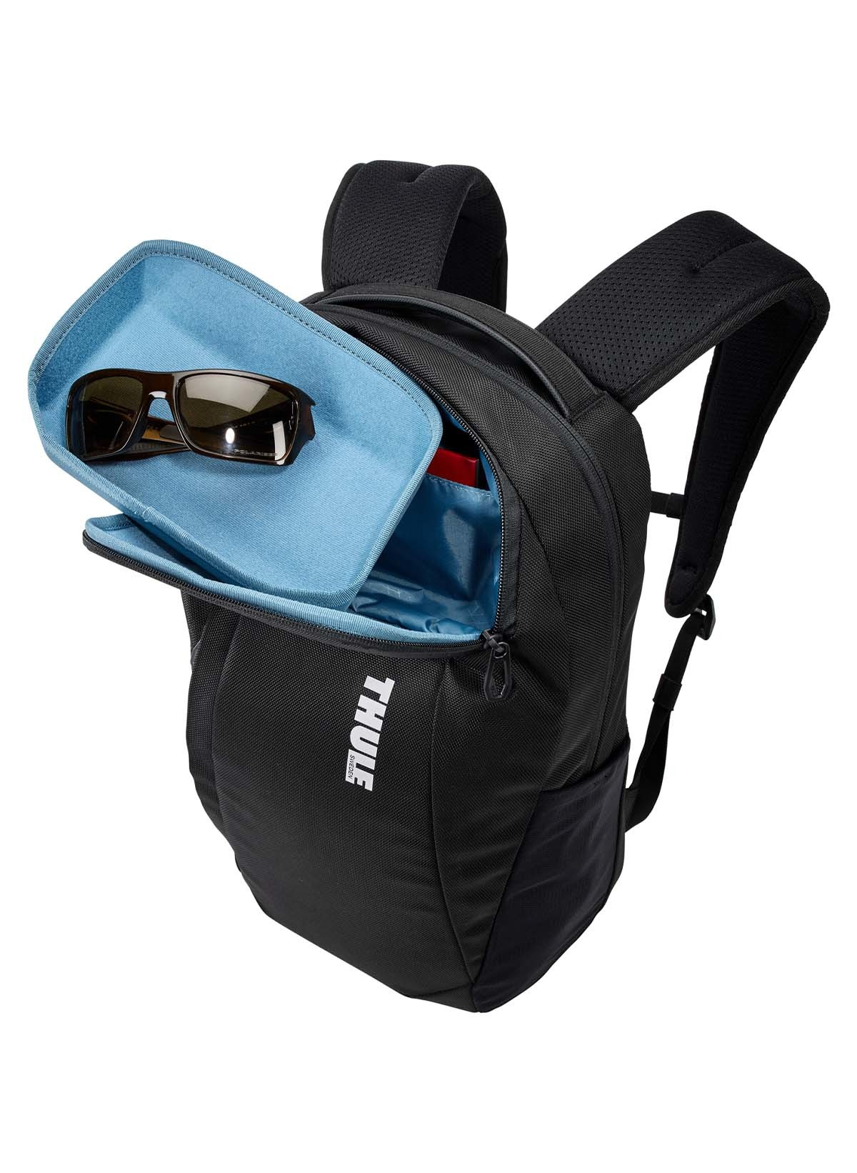 Schwarzer Thule Rucksack geöffnet, enthüllt eine blaue Tasche mit Sonnenbrille und rotem Innenraum.