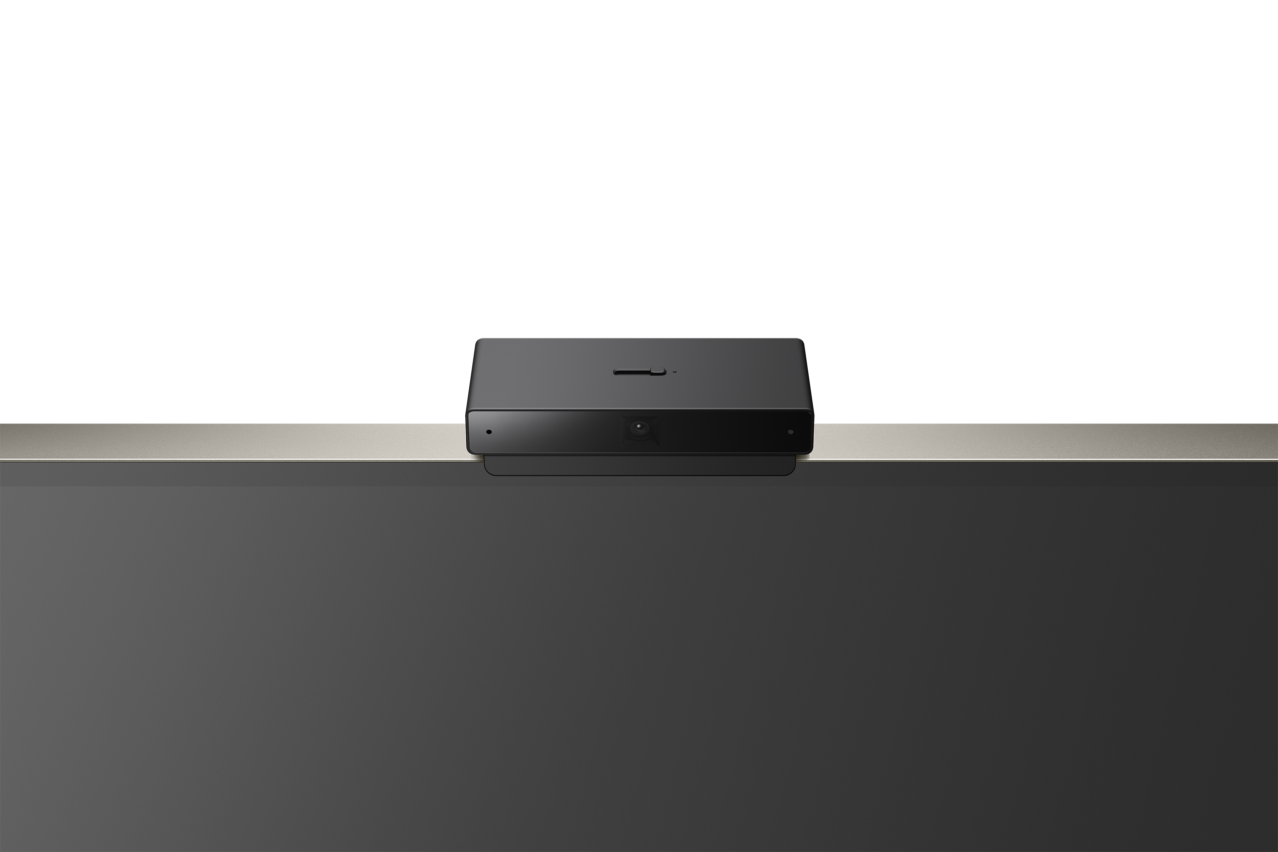 Webcam nera su una superficie bianca su una TV scura con sfondo bianco.