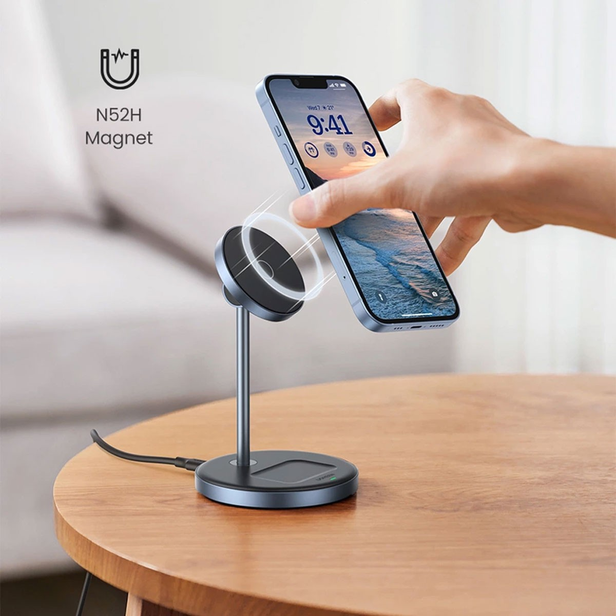 Bir akıllı telefon manyetik bir standa takılı. Bir el, telefonu bir masanın üzerindeki stand üzerinde ayarlıyor.