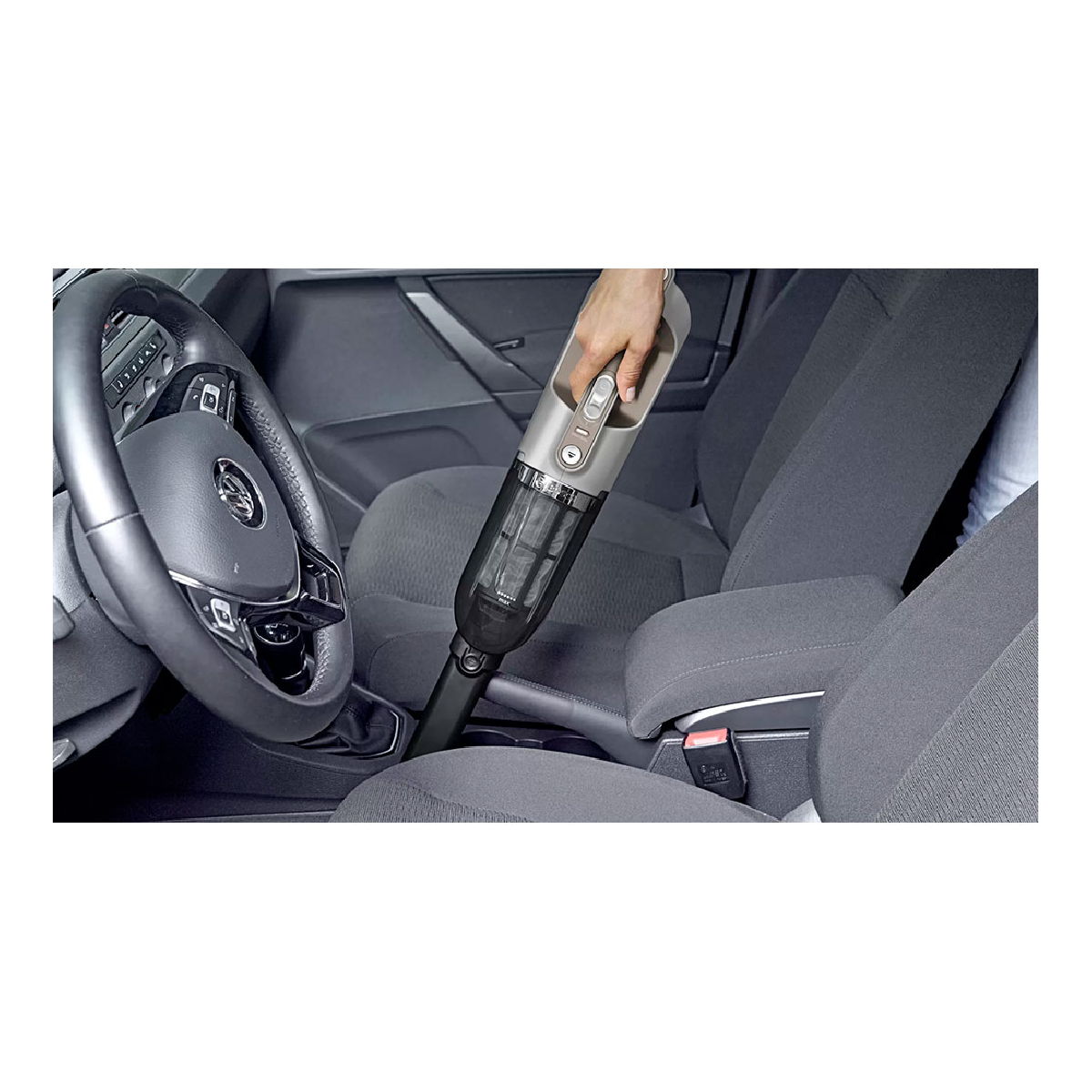 Una mano aspira un asiento de coche con una aspiradora gris. El interior del coche es gris.
