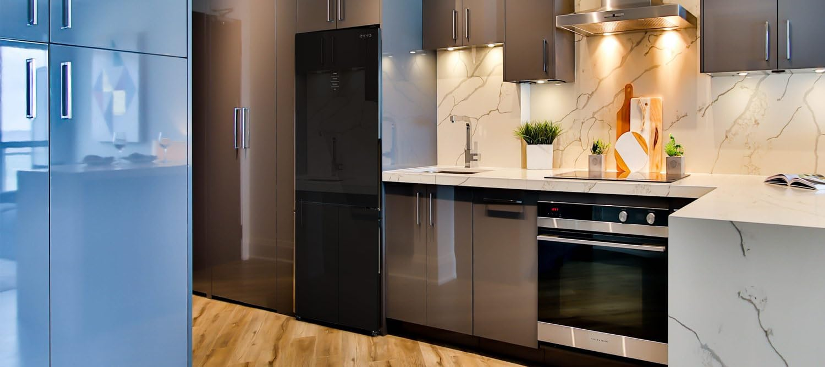 Cocina moderna con electrodomésticos oscuros. Refrigerador, horno y gabinetes negros.