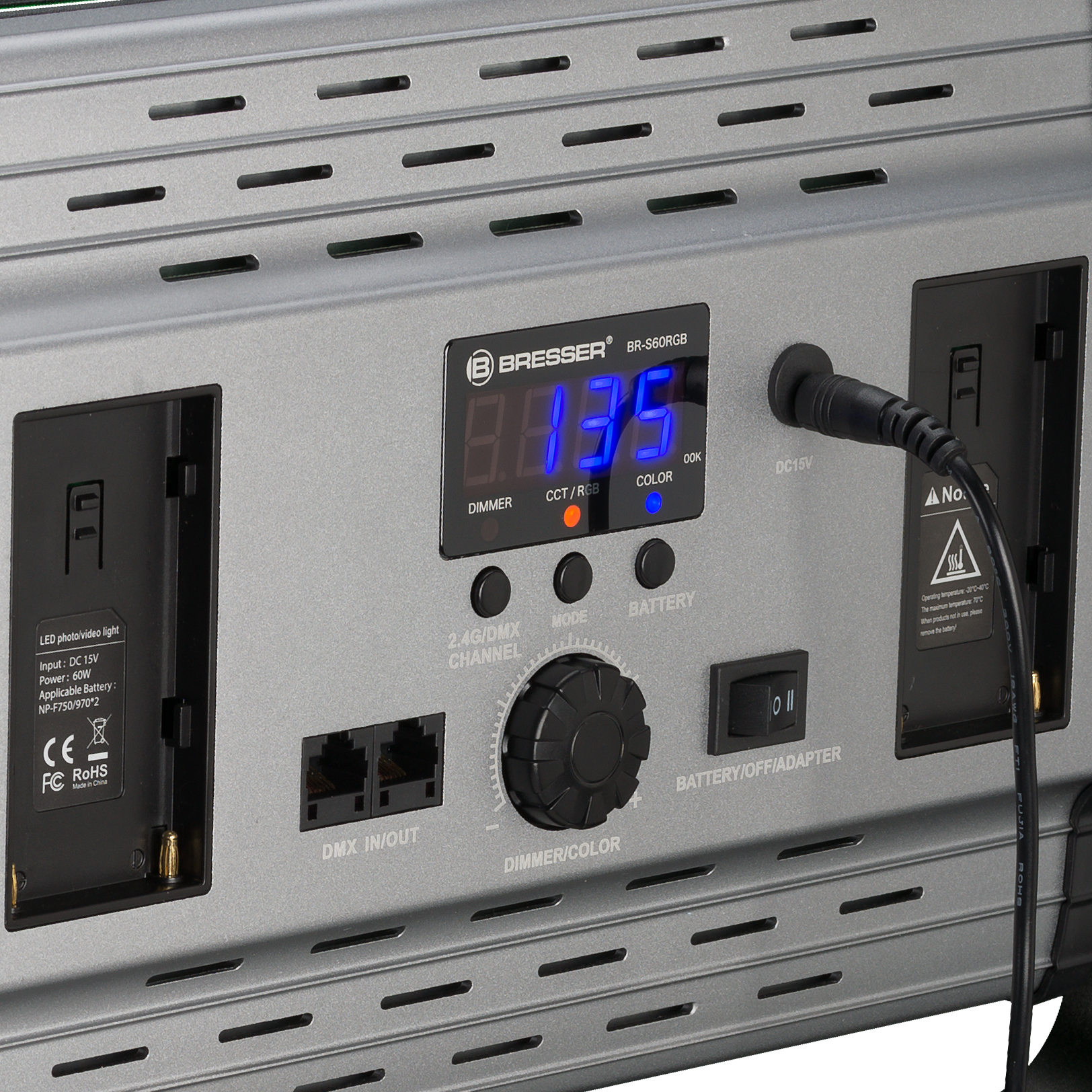 Primer plano de un panel de luz LED gris con pantalla digital y varios controles.