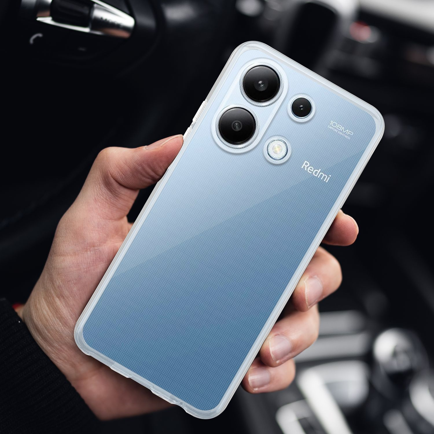 Mano che tiene un telefono blu con tre fotocamere. Il telefono ha un retro blu e una cornice bianca.