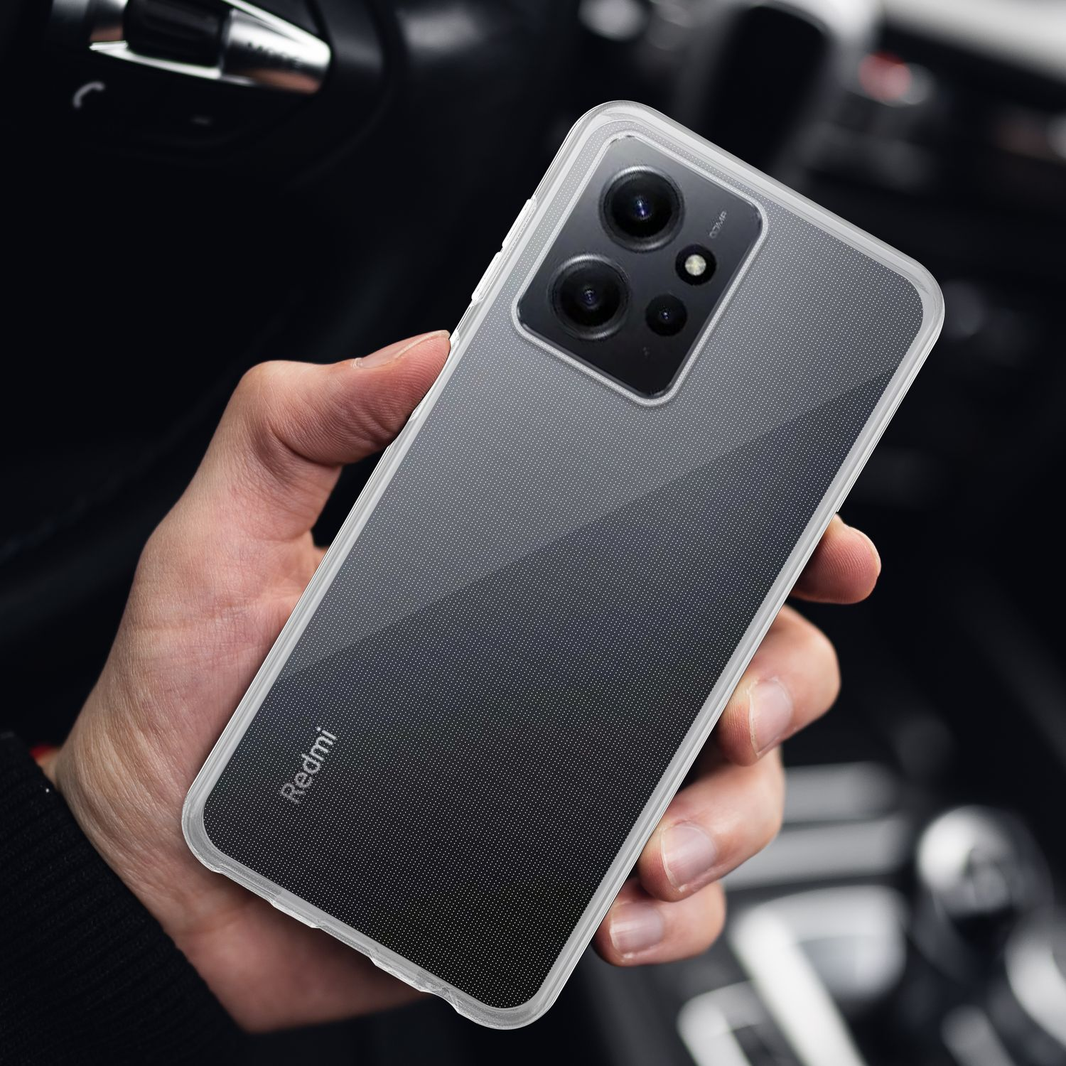 Una mano che tiene una custodia trasparente sopra uno smartphone nero con fotocamera.