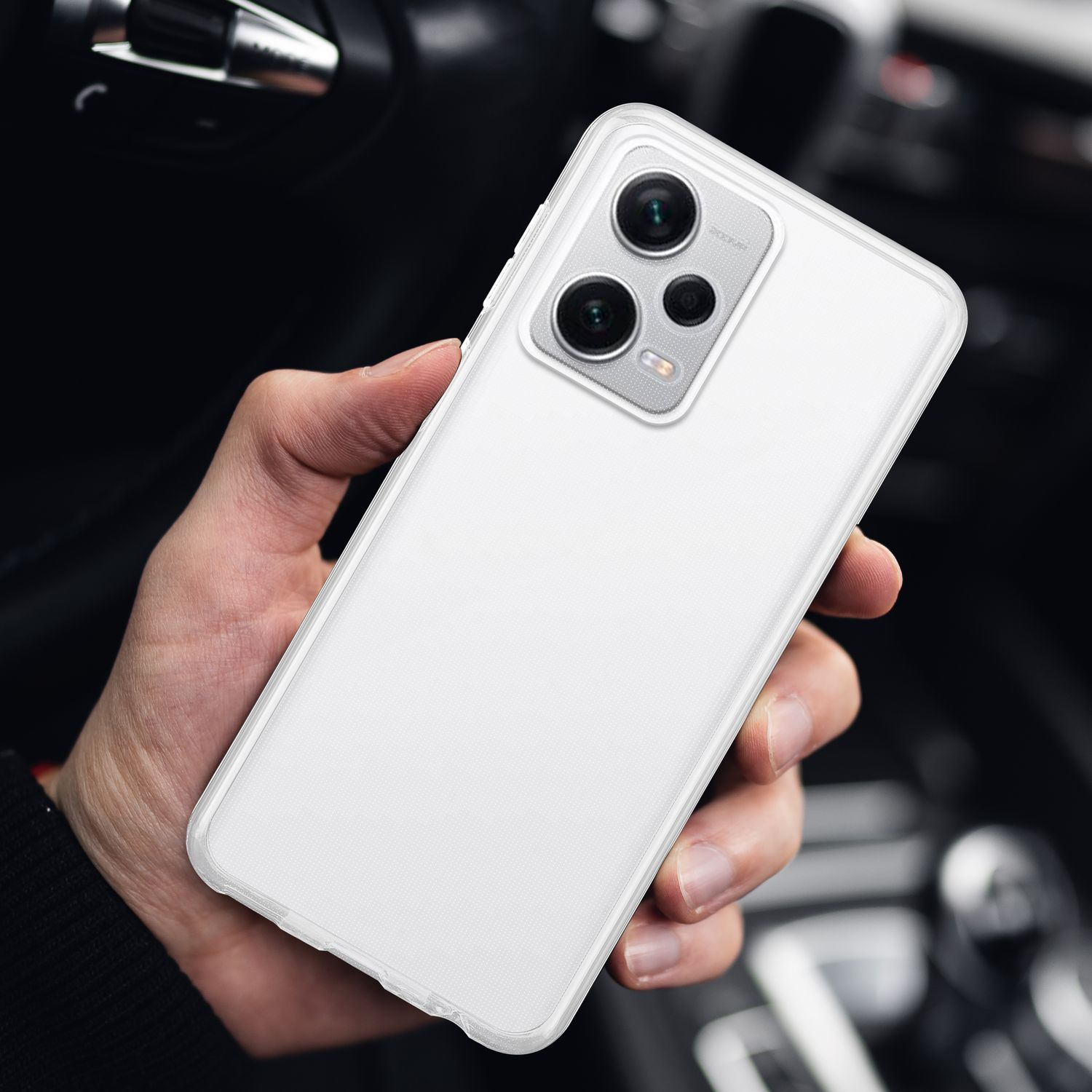Una mano che tiene un telefono bianco con una custodia trasparente che mostra le lenti della fotocamera.