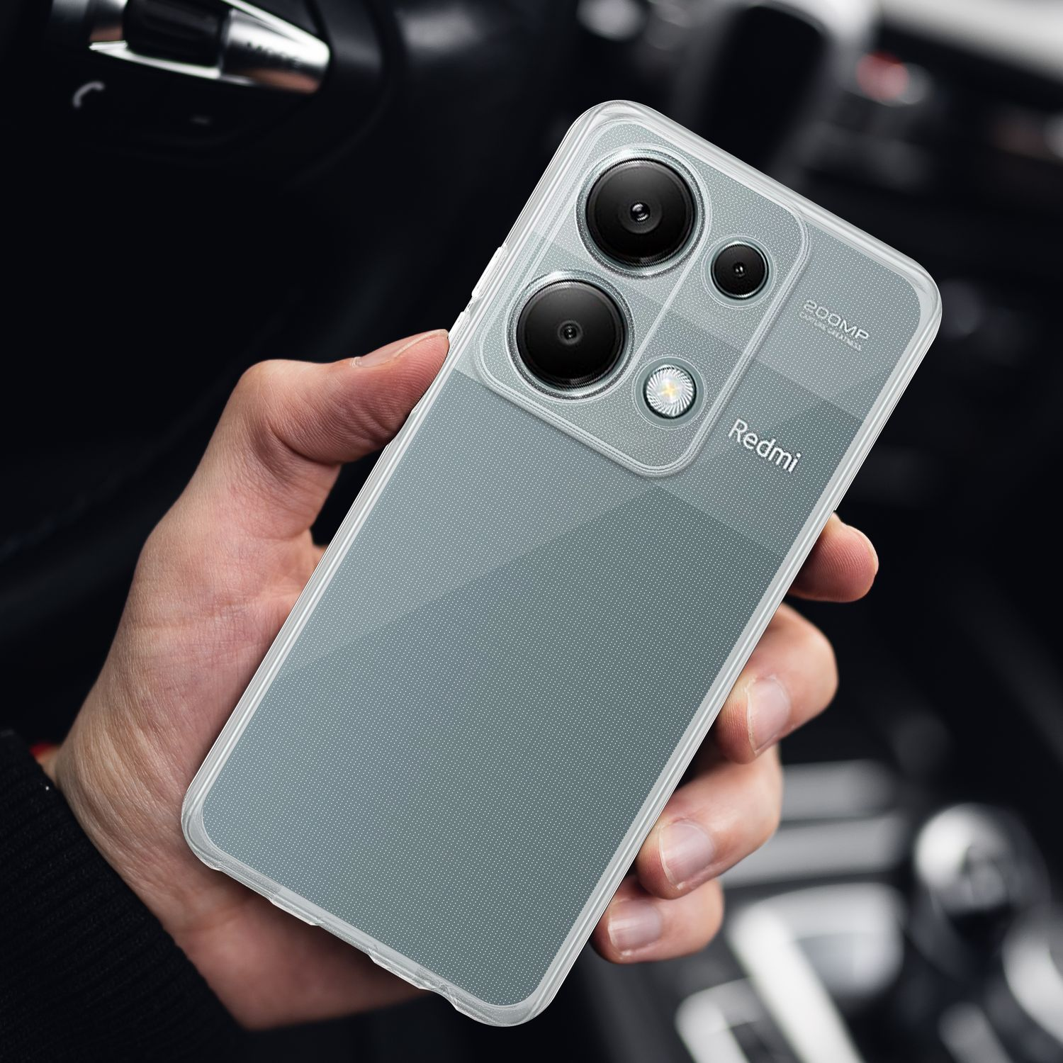 Una mano che tiene un telefono Redmi con una custodia trasparente e più lenti della fotocamera.