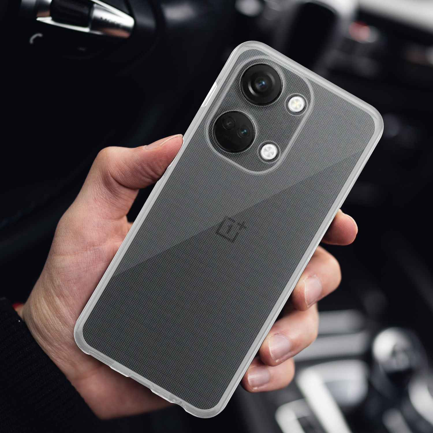 Una mano tiene una custodia trasparente su un telefono nero. Il telefono ha due fotocamere e un logo.
