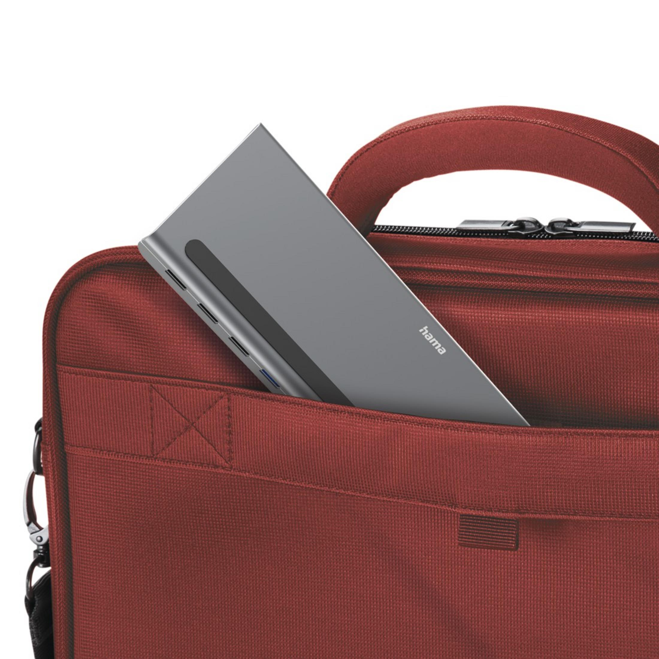 Szare, prostokątne urządzenie w czerwonej torbie. Urządzenie ma wiele portów.