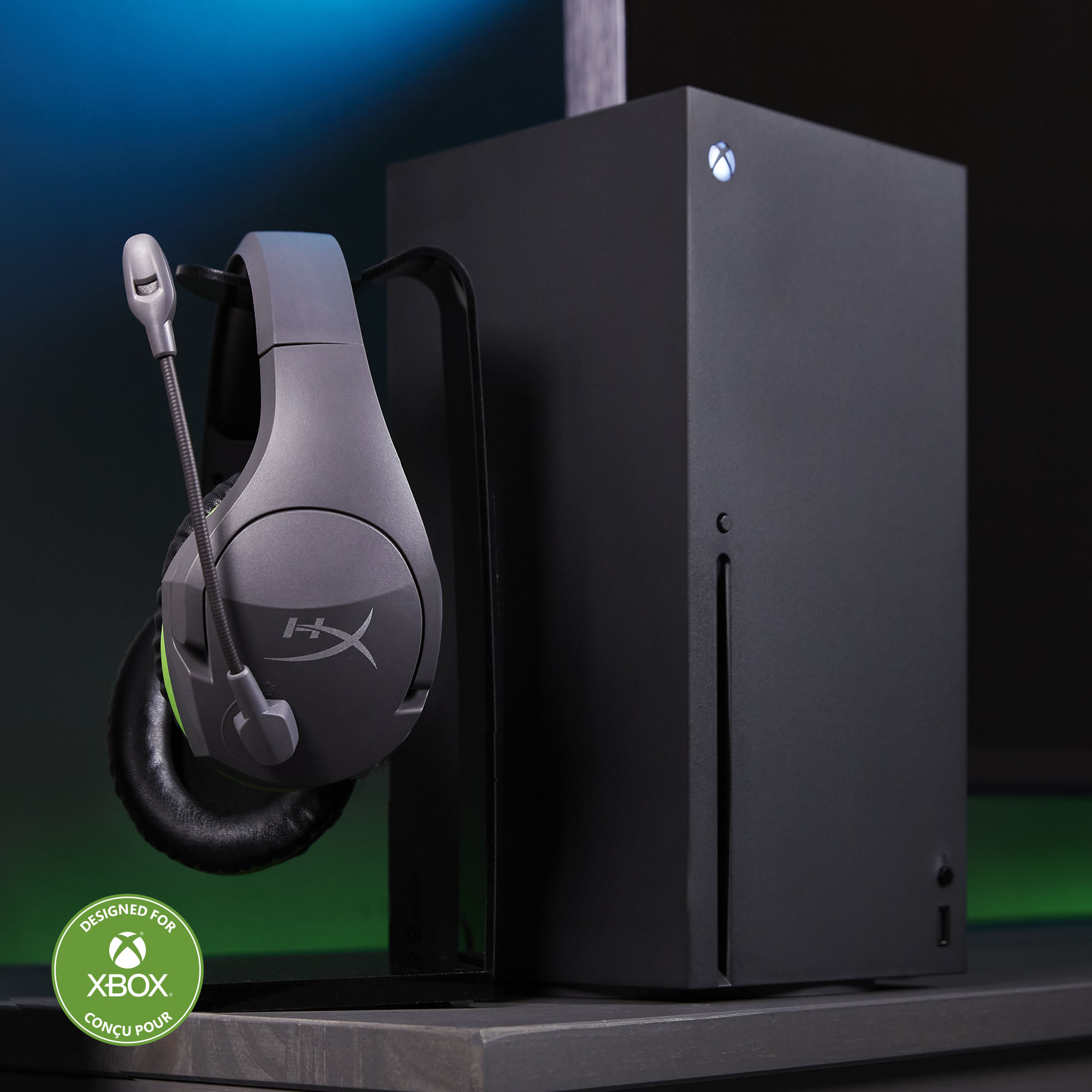 Xbox Series X-Konsole und graues Headset. Das Headset befindet sich auf einem Ständer.
