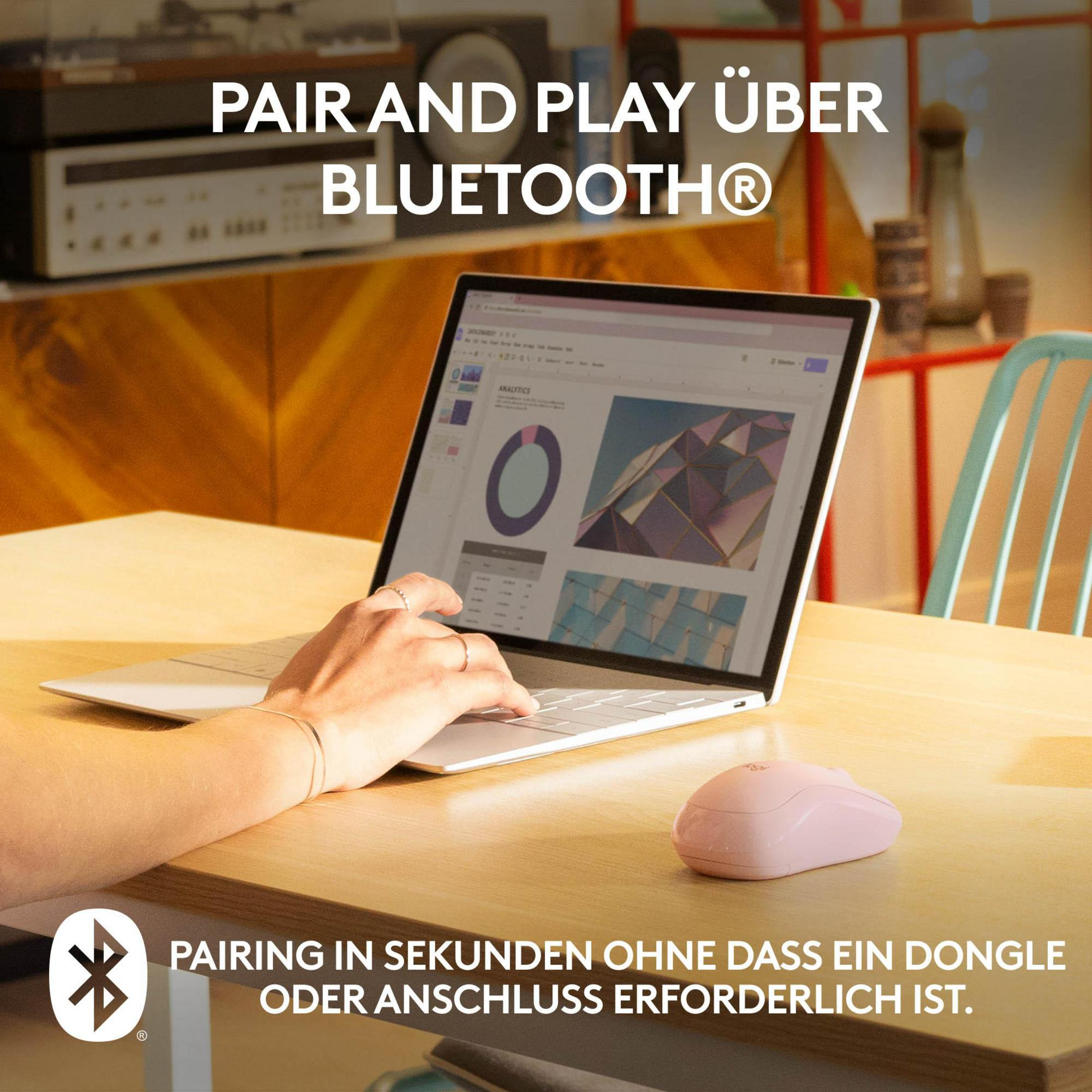 Ręce używają laptopa i różowej myszy na drewnianym stole. Laptop wyświetla dane.