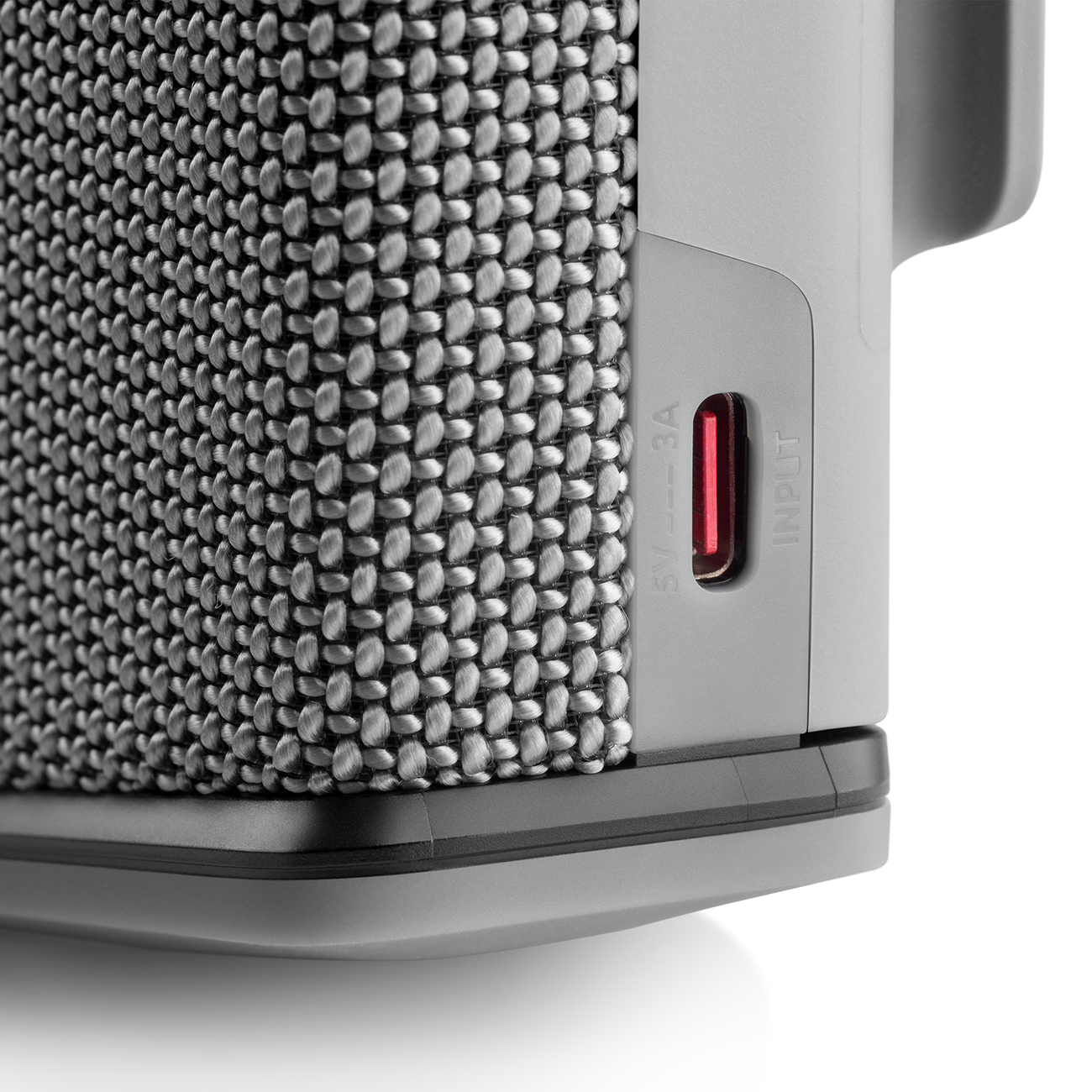Close-up of a gray and black speaker with a USB-C port visible.
