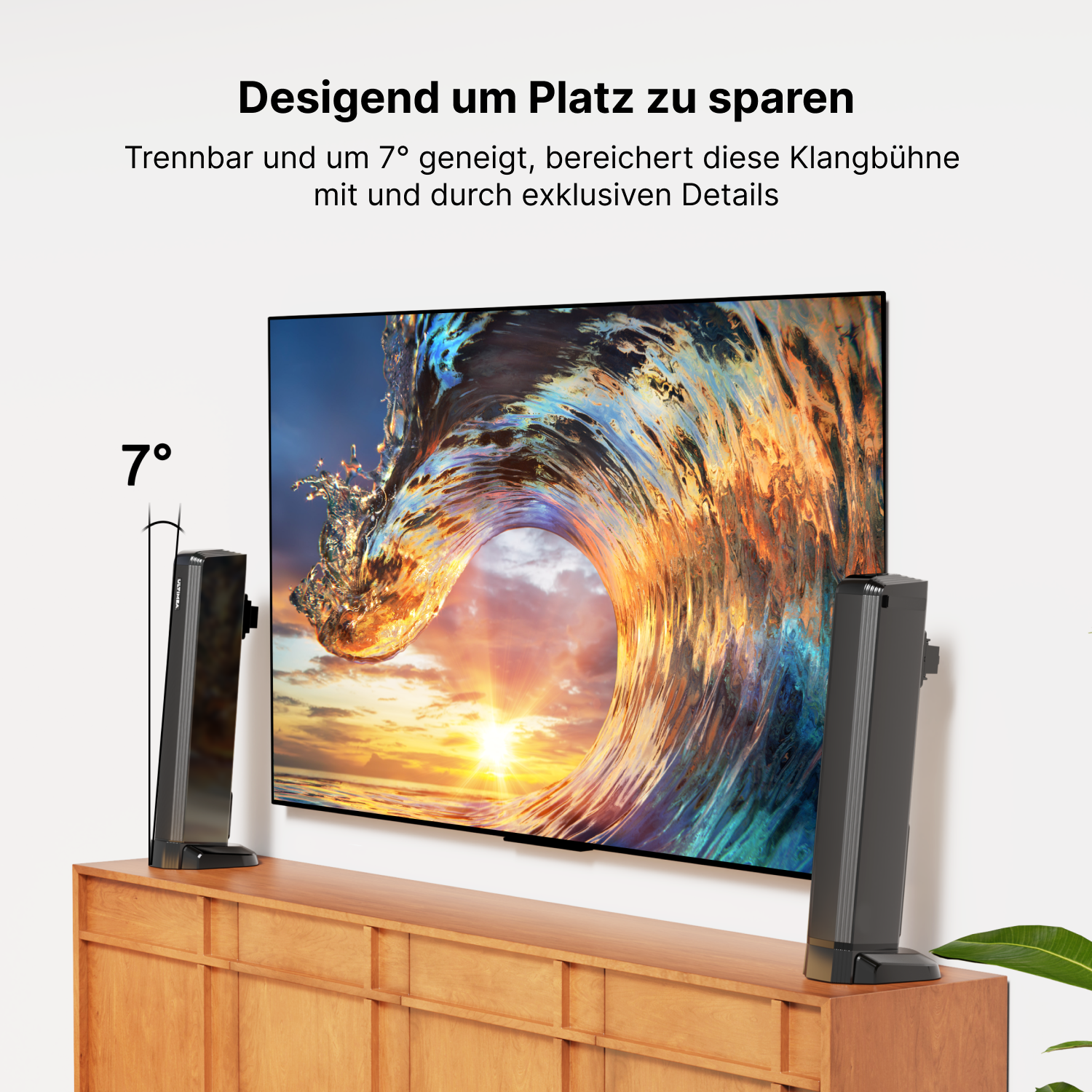 Zwei schwarze Lautsprecher, die auf einen Fernseher ausgerichtet sind. Sie stehen auf einem Holzschrank.