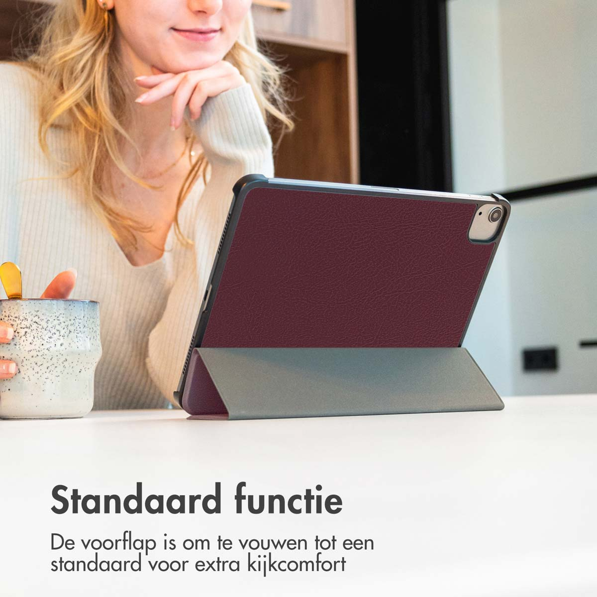 Tablet in rotem Case auf Tisch. Frau schaut drauf. Text: Standardfunktion.